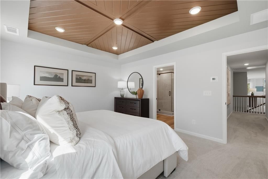 Elegant owner's suite with wood plank tray ceiling and tiled walk-in shower in Davidson Homes The Sinclair B, Cartersville, GA