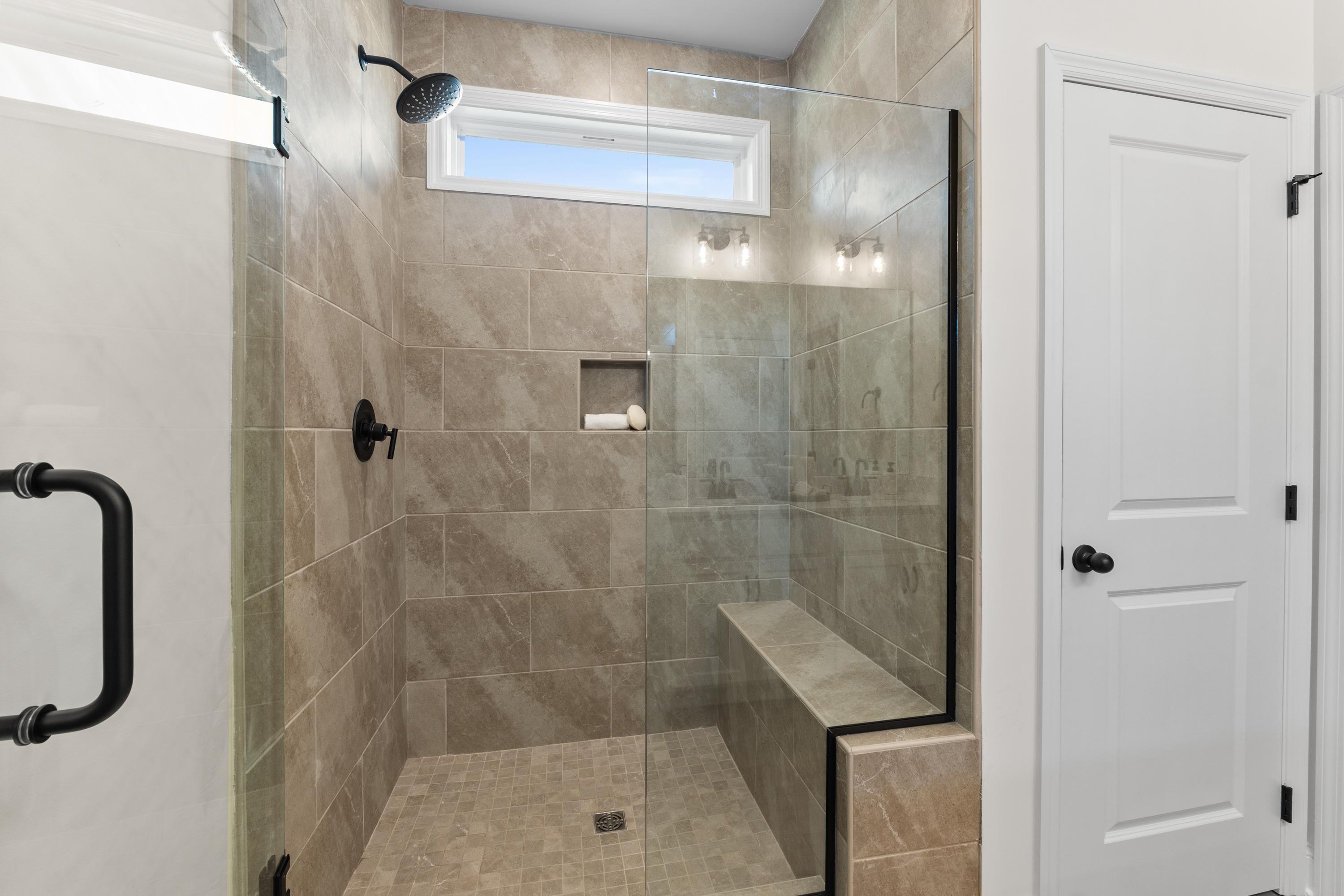 Spacious tiled walk-in shower in Lynn Meadows home, Meridianville Alabama with glass enclosure, bench seat and rainfall showerhead