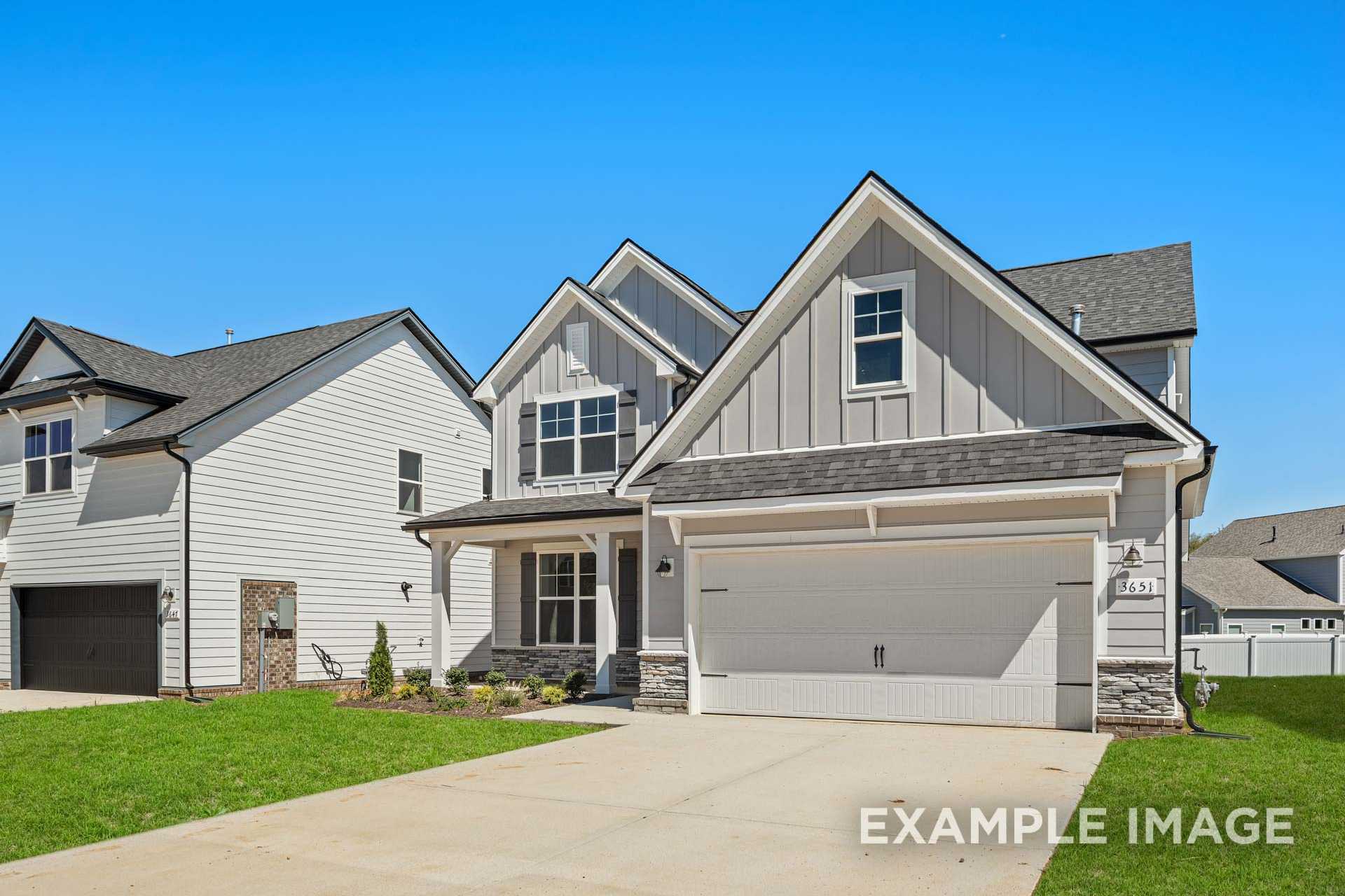 Two-story The Ash B home elevation with gray siding, two-car garage, and manicured front yard in Mt. Juliet