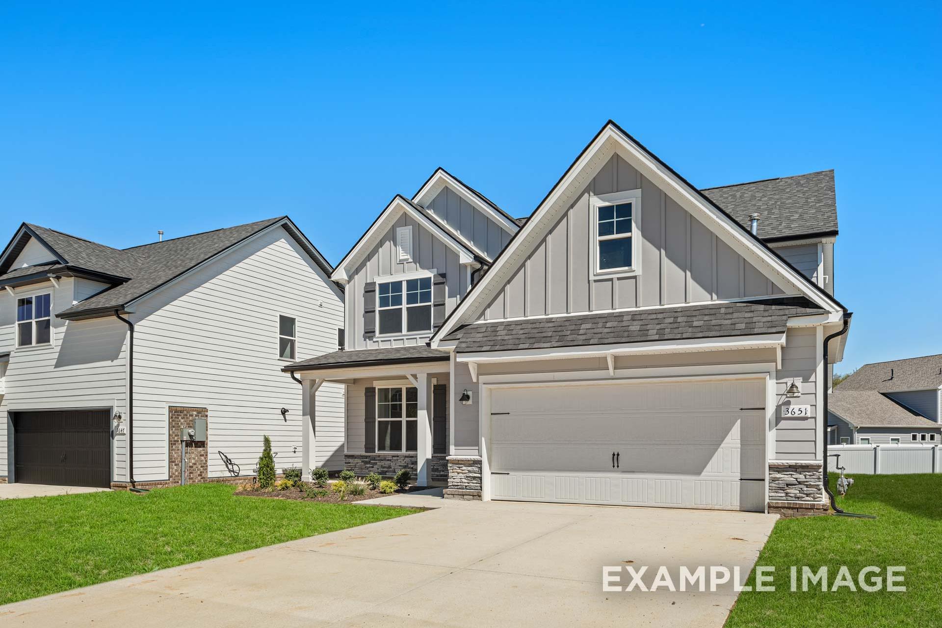 Two-story The Ash B home elevation with gray siding, two-car garage, and manicured front yard in Mt. Juliet