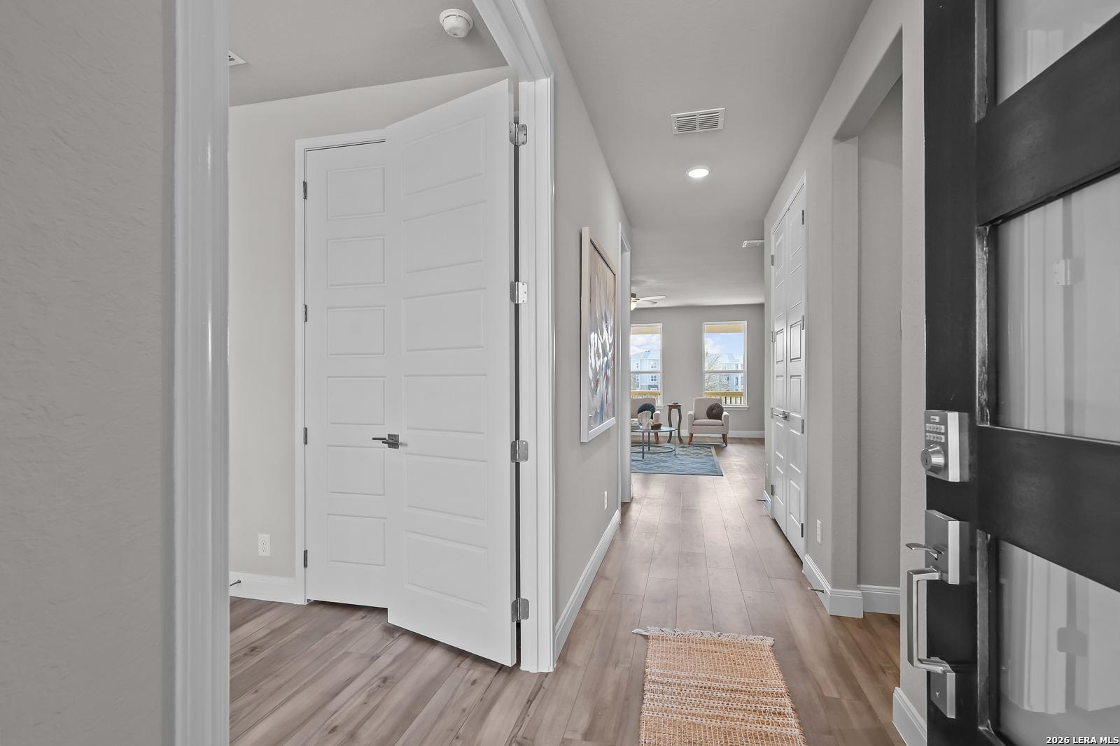 Welcoming entryway with open hallway, hardwood floors, white doors, and natural light in Davidson Homes The Rockford G, Ladera, San Antonio