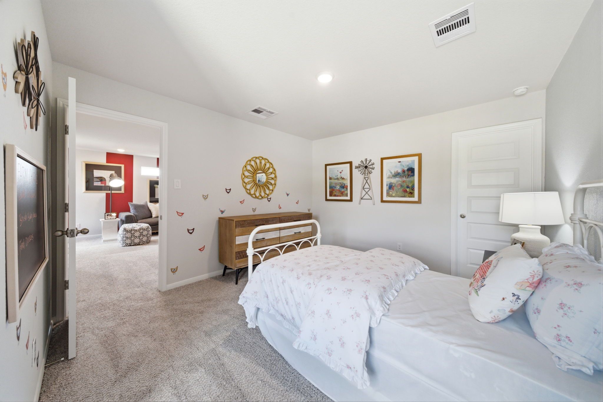 Cozy girl's bedroom at Liberty Estates in Cleveland, Texas with twin bed, pink floral bedding, butterfly decals and windmill art