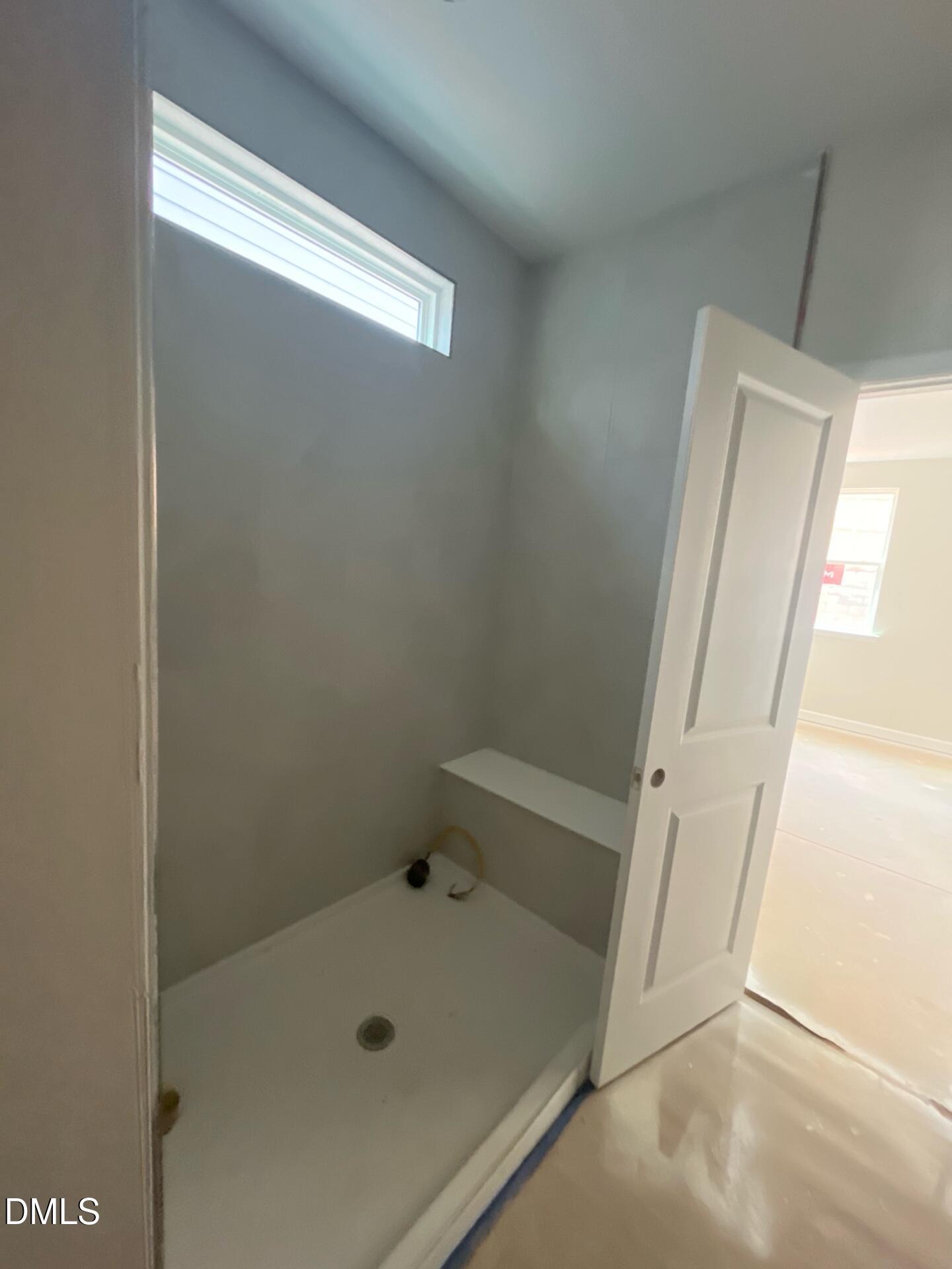 Modern walk-in shower with glass door and built-in niche in primary bathroom, The Ashport G by Davidson Homes, Wake Forest NC