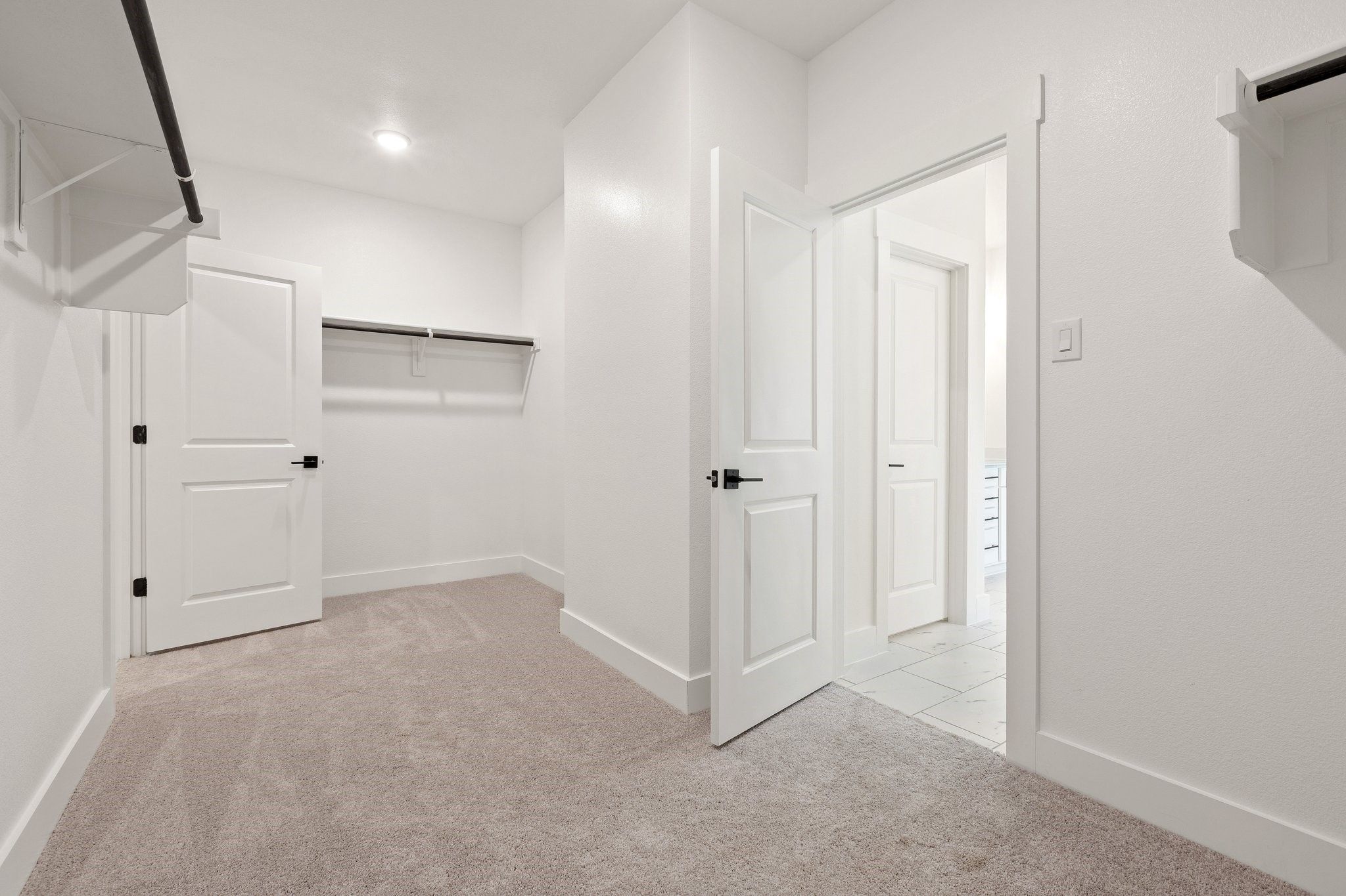 Walk-in closet with carpeted flooring and shelving in The Rockford C floor plan at Waverly Estates, Josephine, Texas.