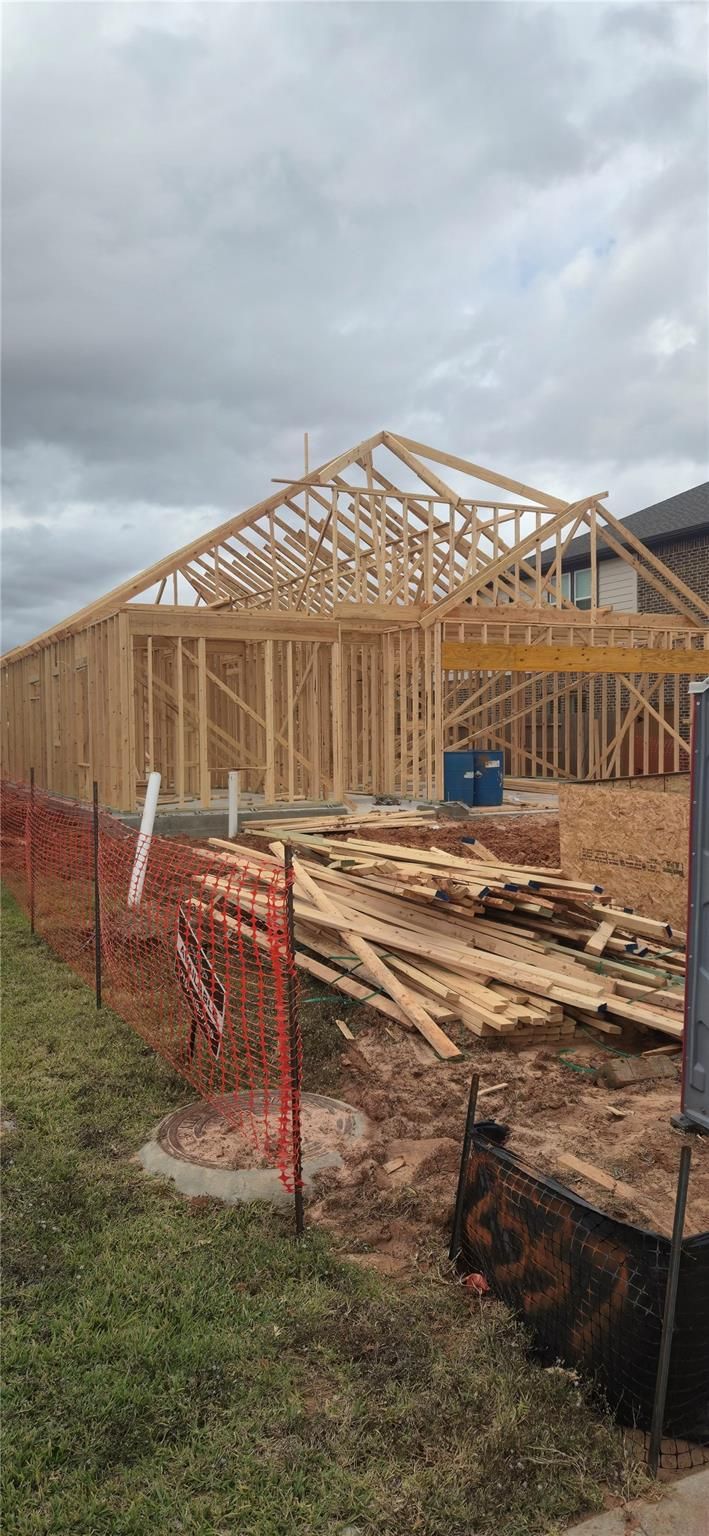 Wooden framed single-story home with gable roof under construction in Sunterra, Katy, Texas - The Luna J by Davidson Homes