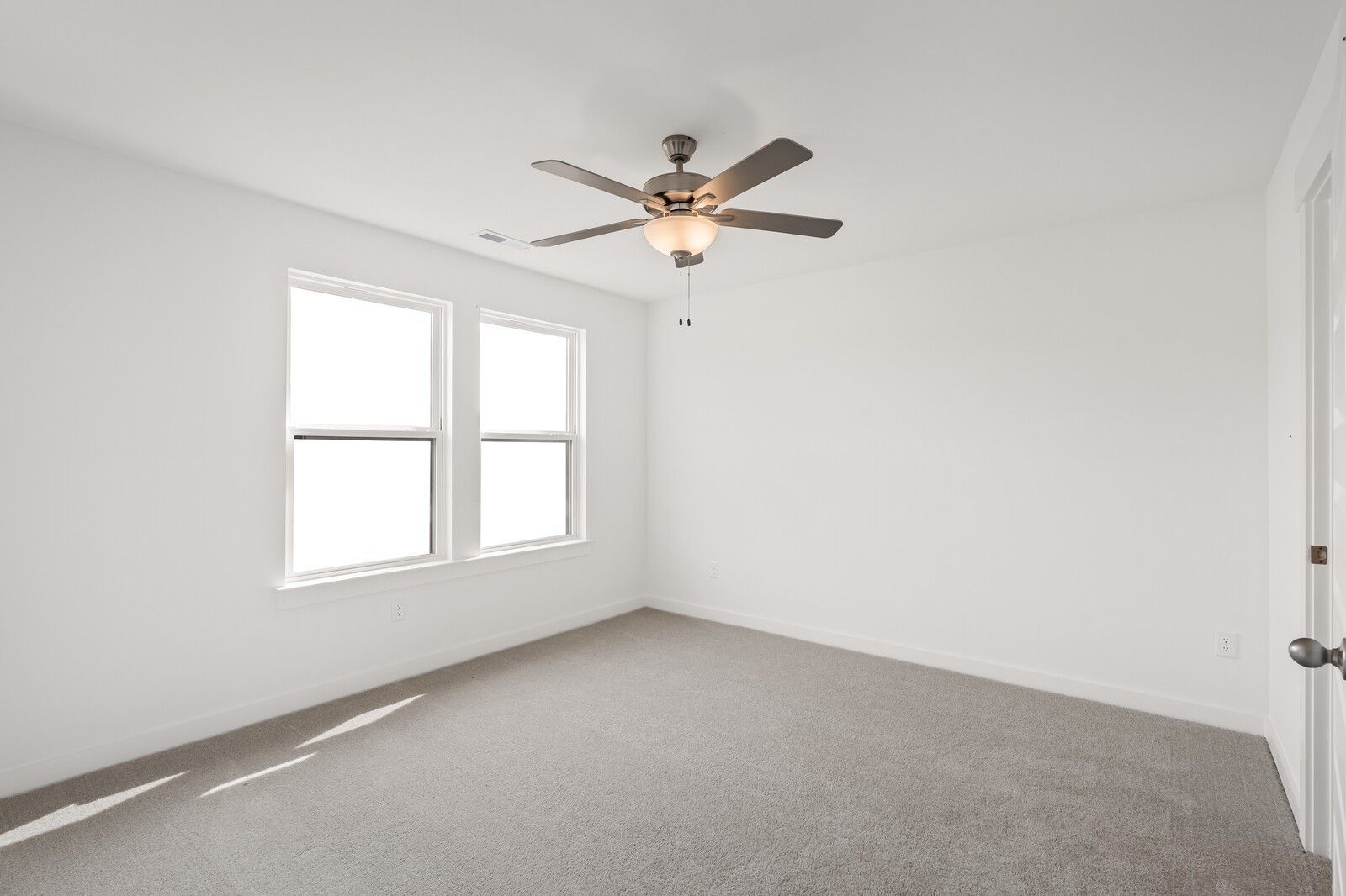 Bright, spacious bedroom with neutral carpet and ceiling fan in The Willow D floor plan at Benders Cove, Mt. Juliet, TN.