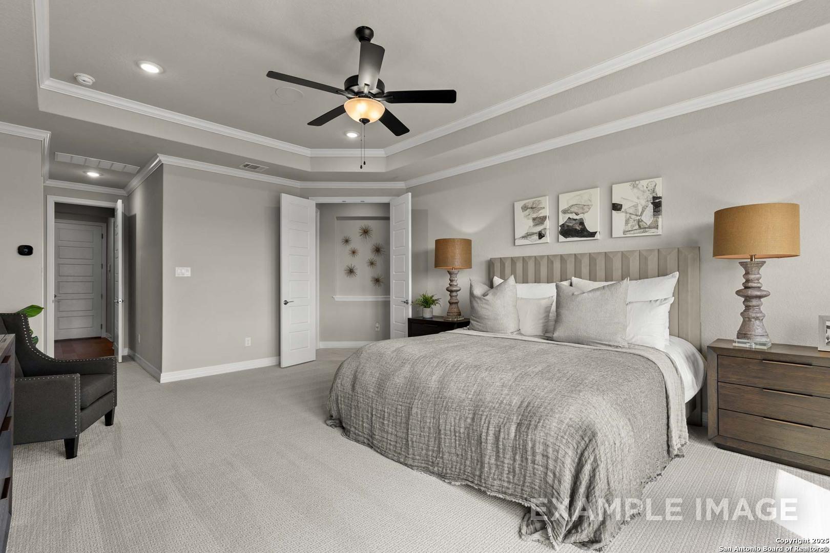 Luxurious master bedroom with king bed, ceiling fan, and en-suite door in Davidson Homes The Summerlin B, Castroville, Texas