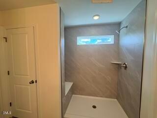Modern walk-in shower with tiled walls in The Willow B floor plan at Woodland Crossing, Zebulon, North Carolina.