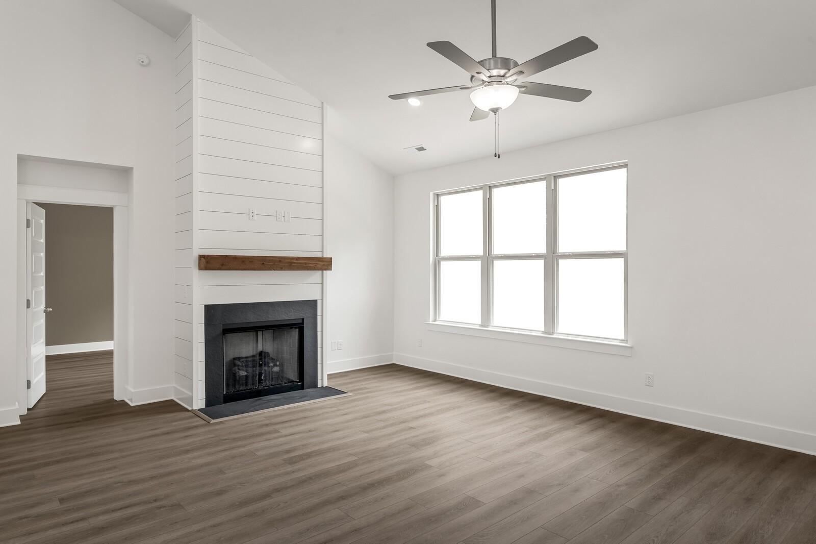 Bright living room with shiplap fireplace and vaulted ceilings in The Ridgeport C floor plan, Woods Crossing, Gallatin, TN.