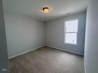 Spacious secondary bedroom with neutral carpet in The Daphne D floor plan at Woodland Crossing in Zebulon, North Carolina.