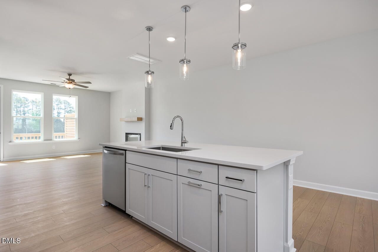 Modern kitchen island with quartz countertops and pendant lighting in The Mitchell floor plan at Camden Park, Knightdale.