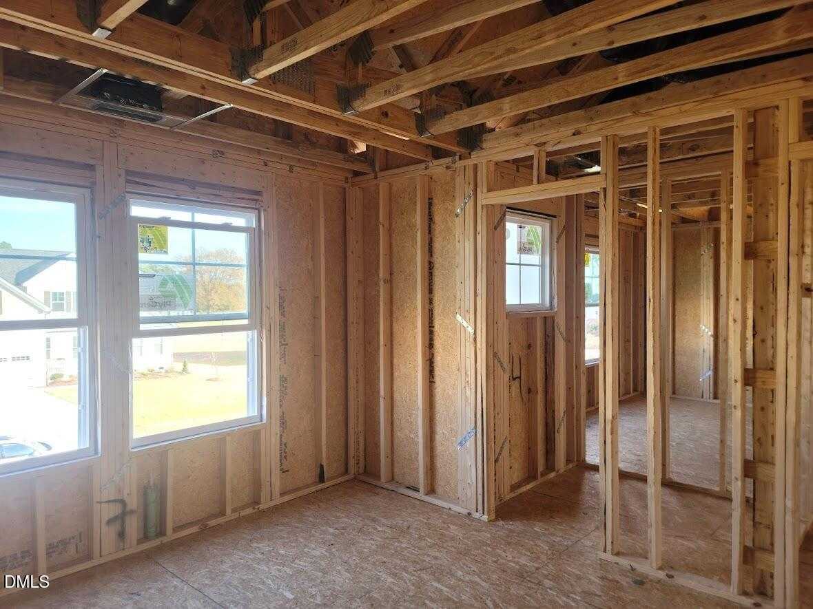 Interior framing of spacious bedroom with large windows and exposed beams in new 5-bedroom Davidson Homes The Willow G, Angier, NC