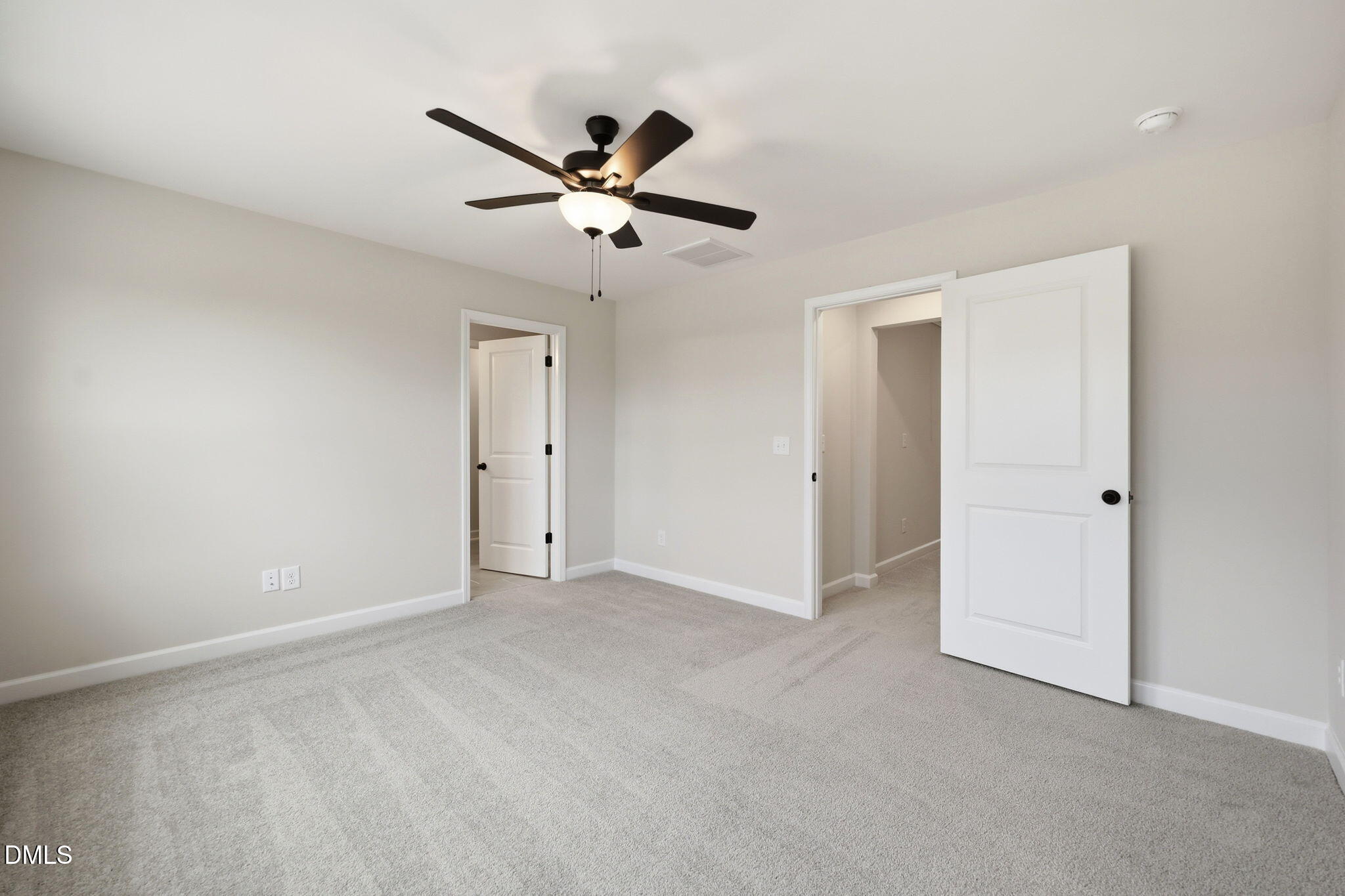 Spacious carpeted bedroom with ceiling fan in The Mitchell floor plan at Camden Park, Knightdale, North Carolina.
