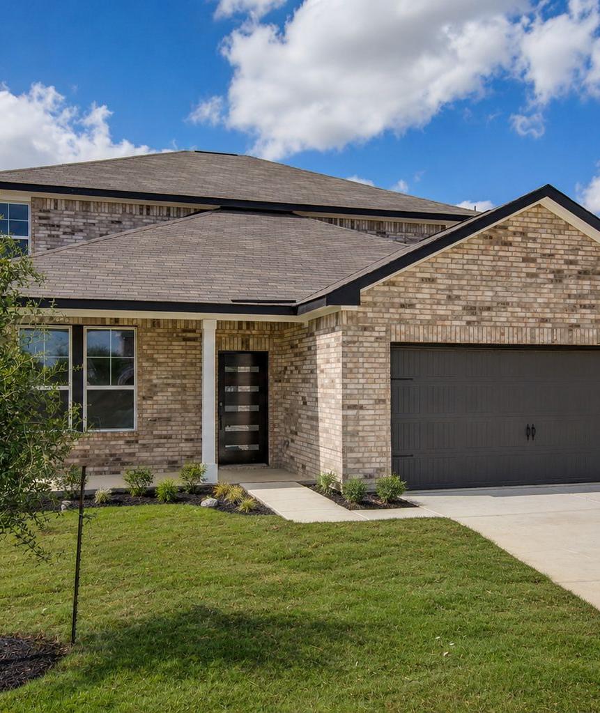 Spacious modern kitchen at Hickory Ridge in Elmendorf TX featuring navy cabinets, quartz counters, stainless appliances, and wood floors