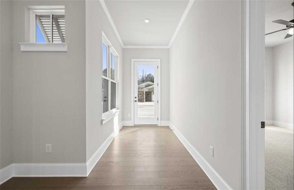 Bright hallway with gray walls, hardwood floors, window, and glass back door in Davidson Homes Seaside A, Woodstock GA