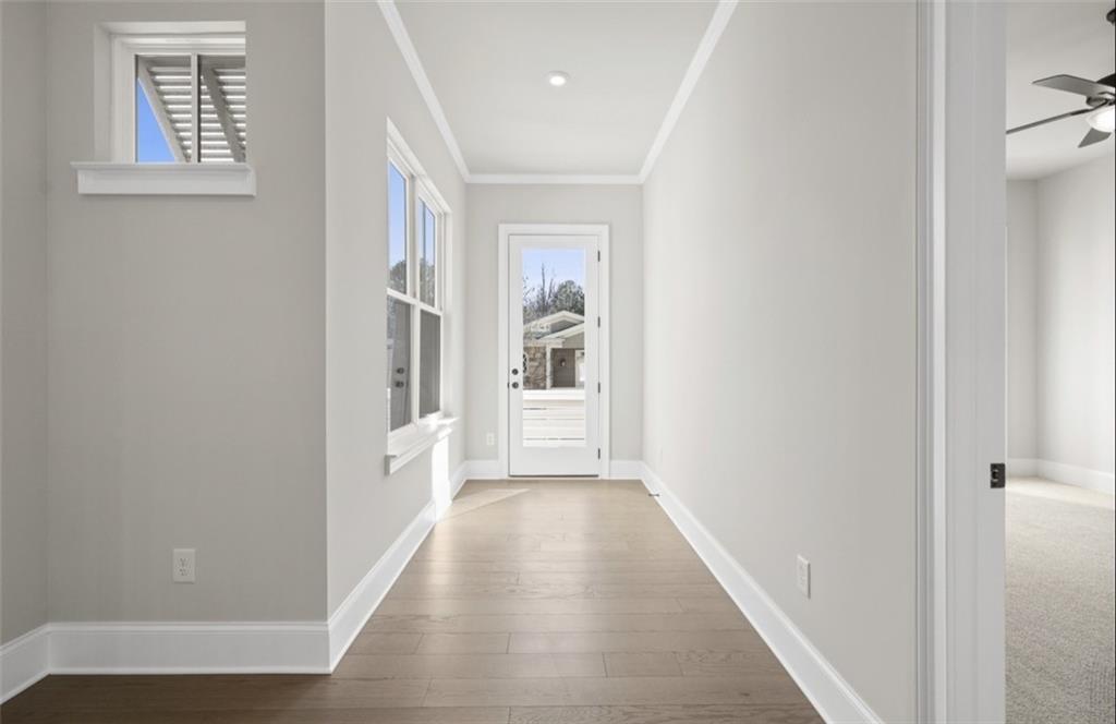 Bright hallway with gray walls, hardwood floors, window, and glass back door in Davidson Homes Seaside A, Woodstock GA