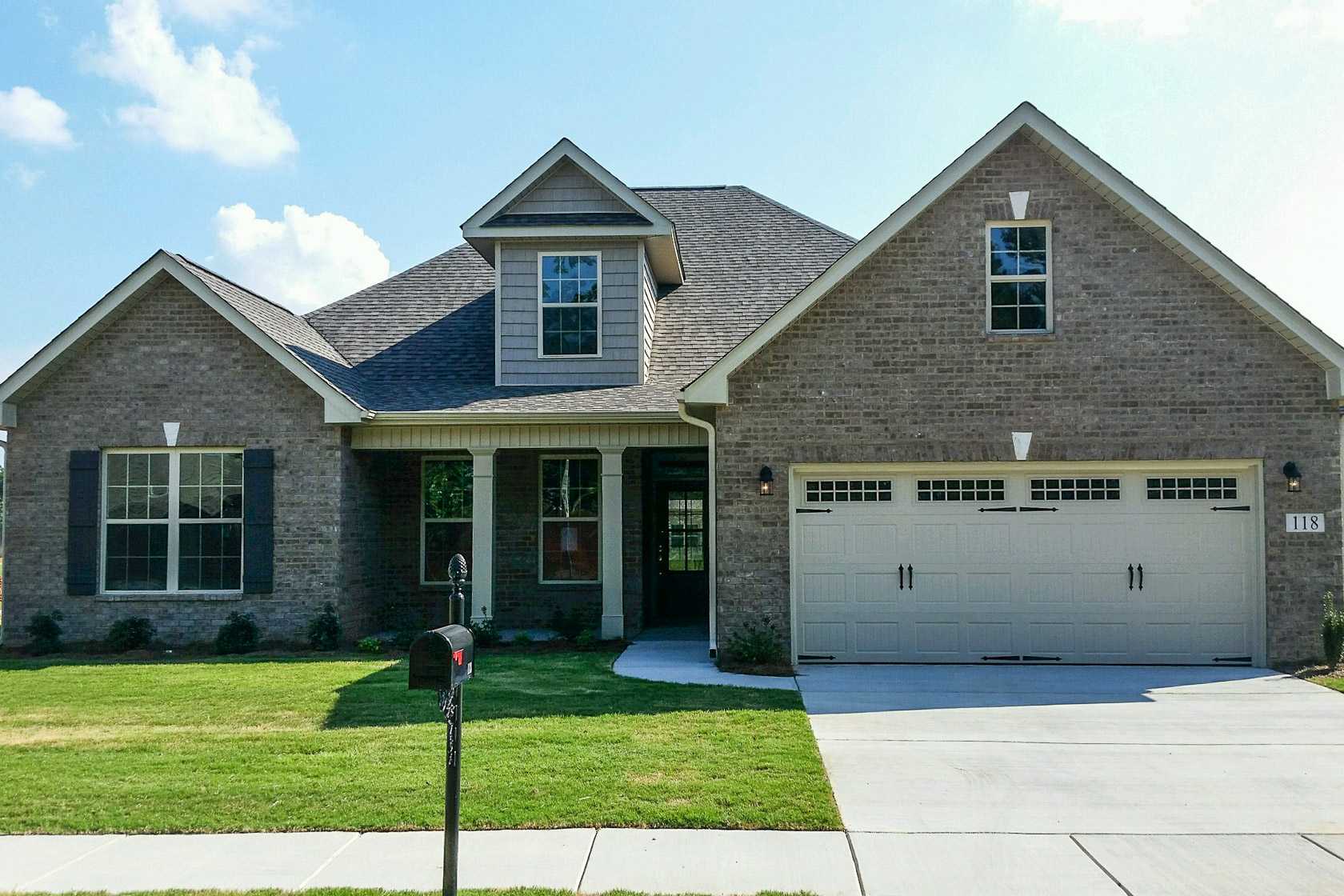 Brick home exterior at Laurenwood Preserve in Madison, Alabama by Davidson Homes featuring gabled roof, garage, and landscaped yard
