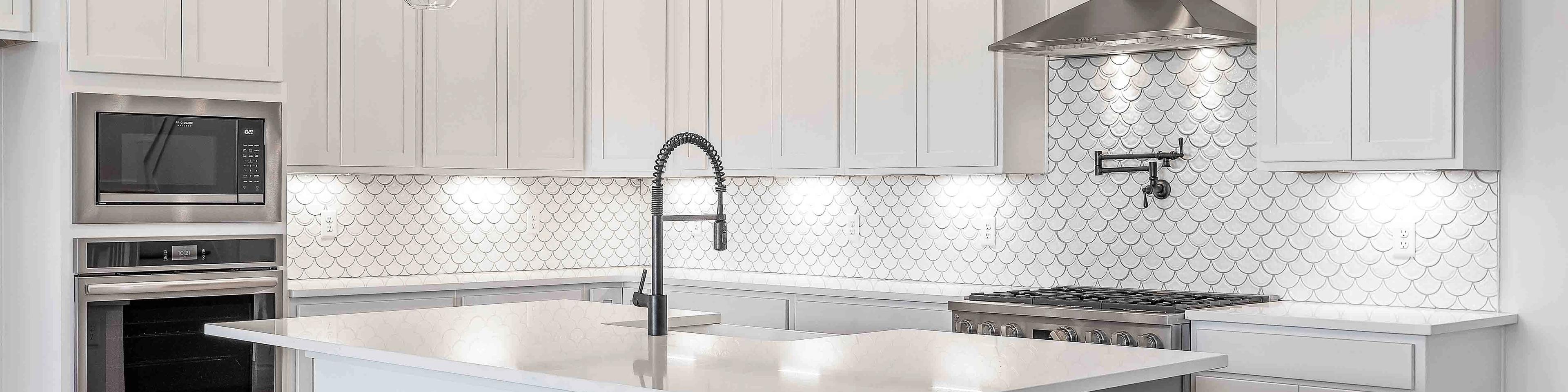 Spacious white kitchen with central island, subway tile backsplash, and pendant lights at Shelton Square in Murfreesboro TN