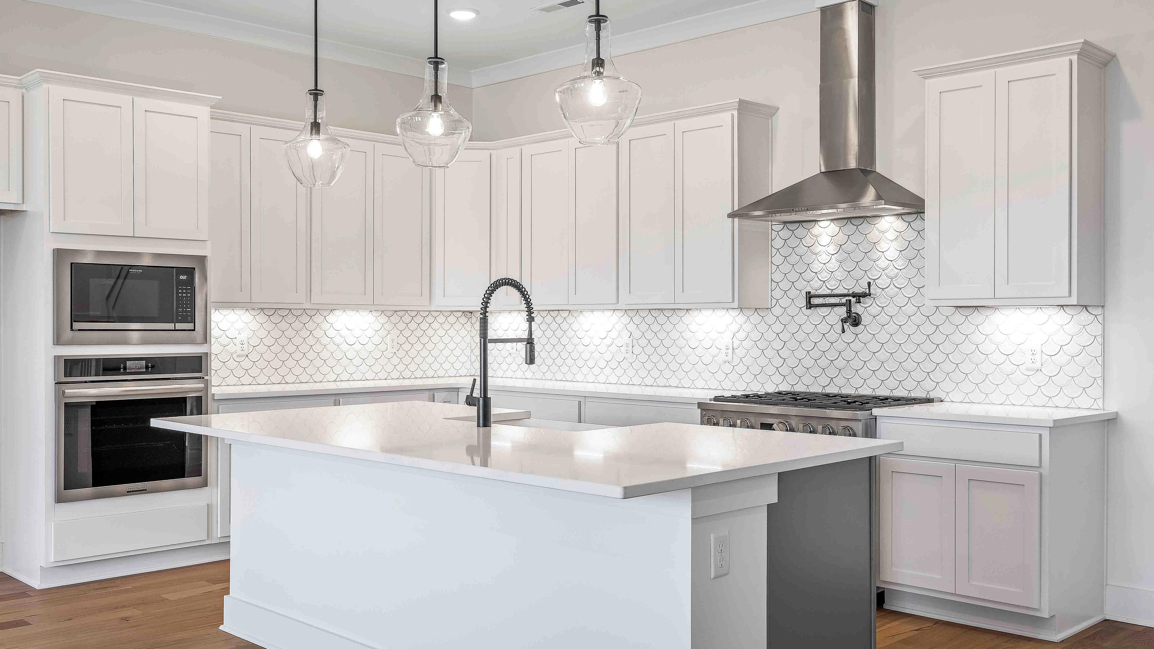 Spacious white kitchen with central island, subway tile backsplash, and pendant lights at Shelton Square in Murfreesboro TN