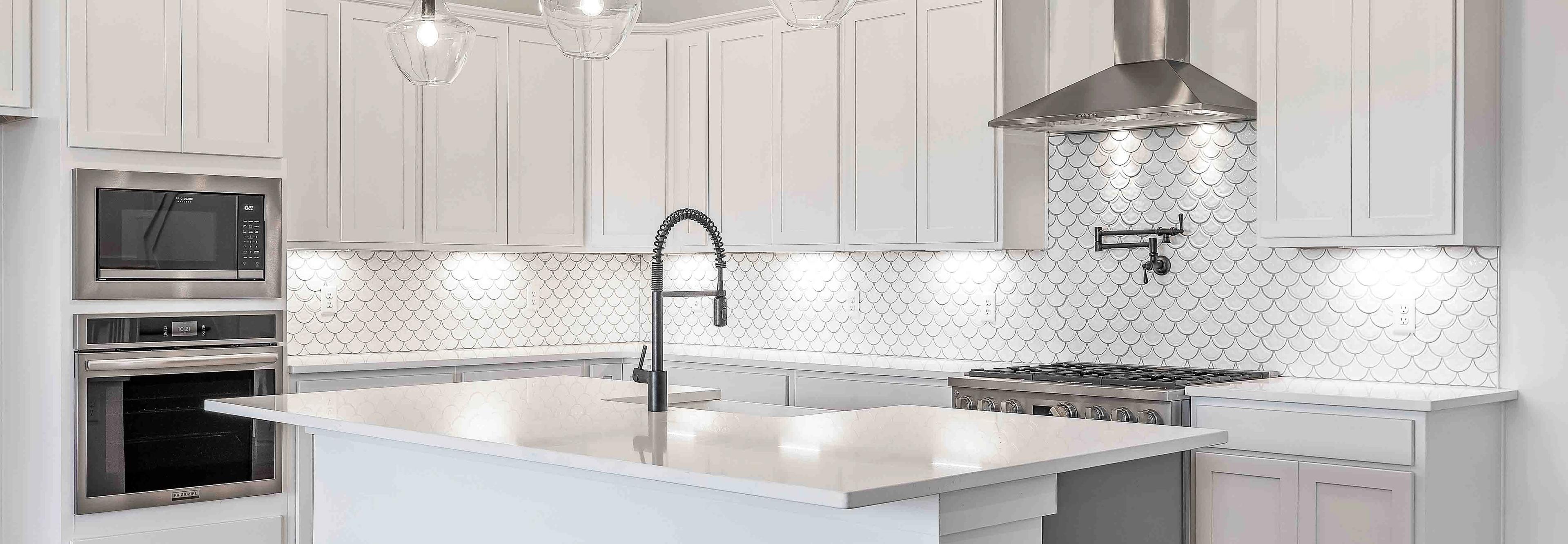 Spacious white kitchen with central island, subway tile backsplash, and pendant lights at Shelton Square in Murfreesboro TN