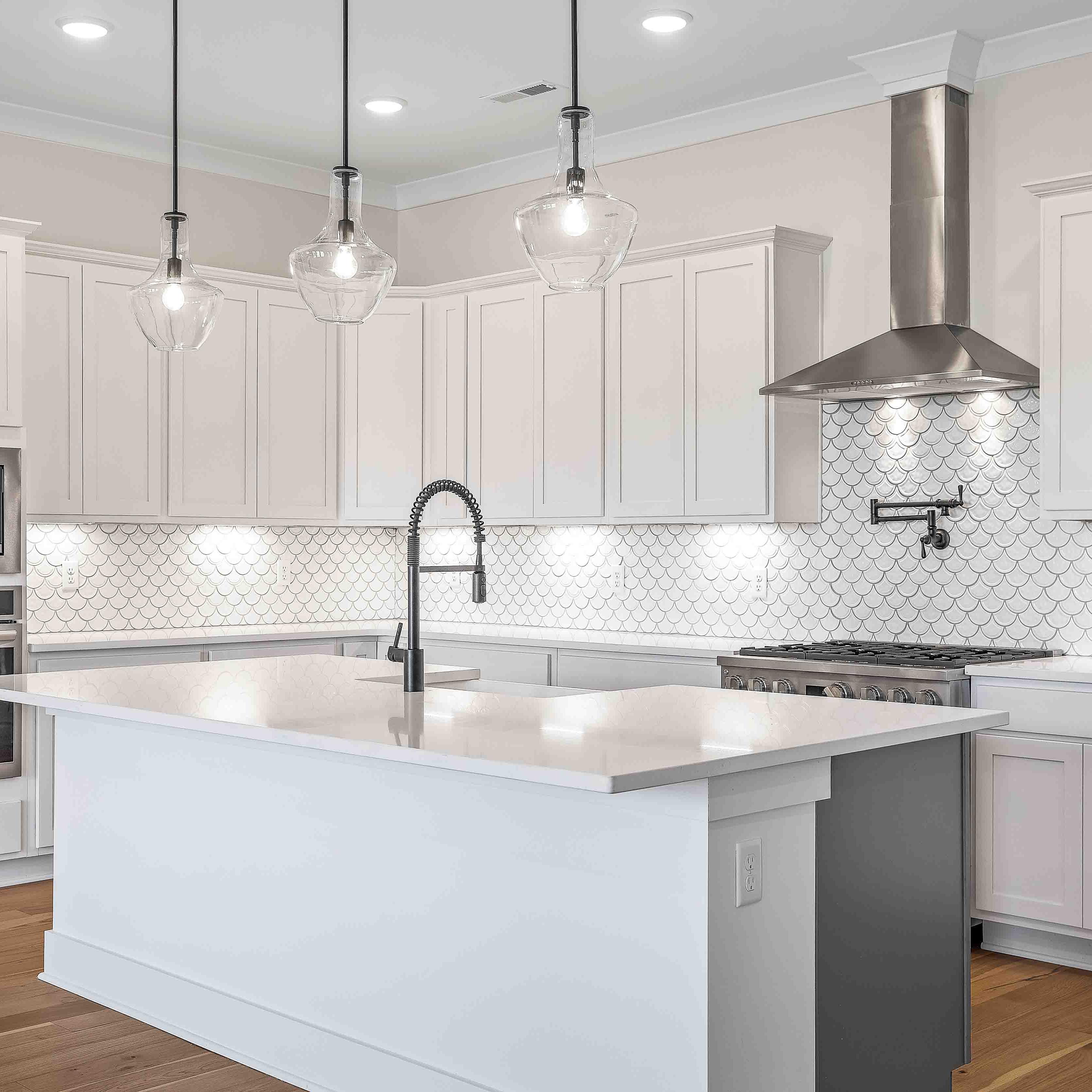 Spacious white kitchen with central island, subway tile backsplash, and pendant lights at Shelton Square in Murfreesboro TN