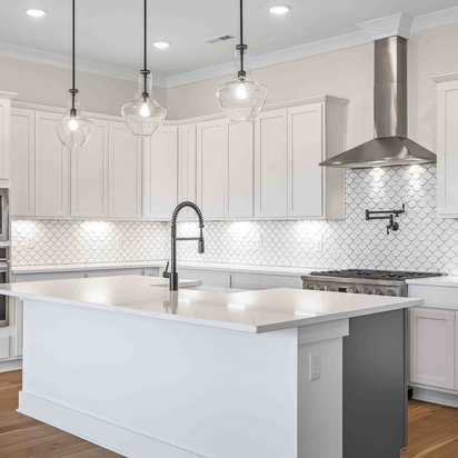 Spacious white kitchen with central island, subway tile backsplash, and pendant lights at Shelton Square in Murfreesboro TN