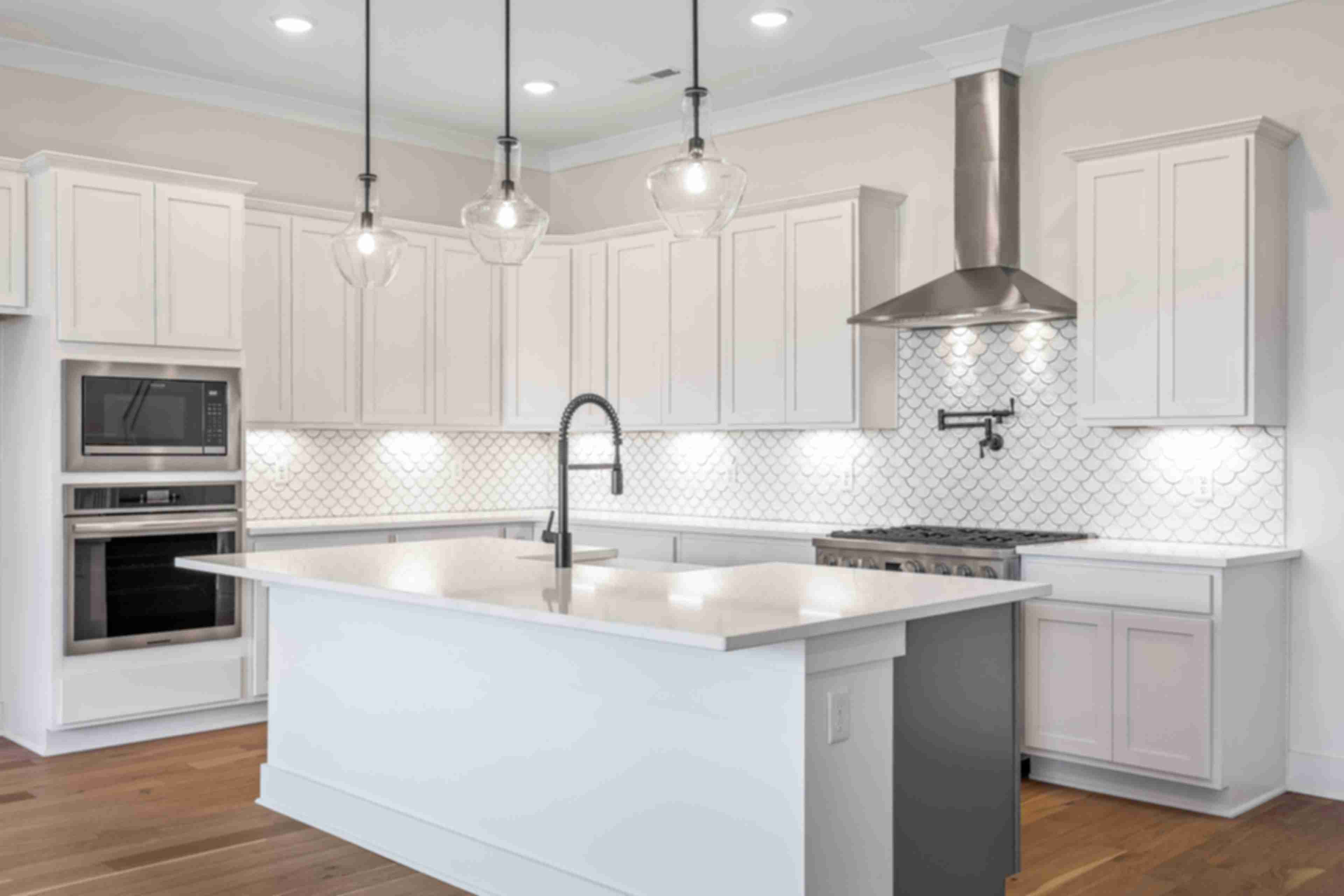 Spacious white kitchen with central island, subway tile backsplash, and pendant lights at Shelton Square in Murfreesboro TN