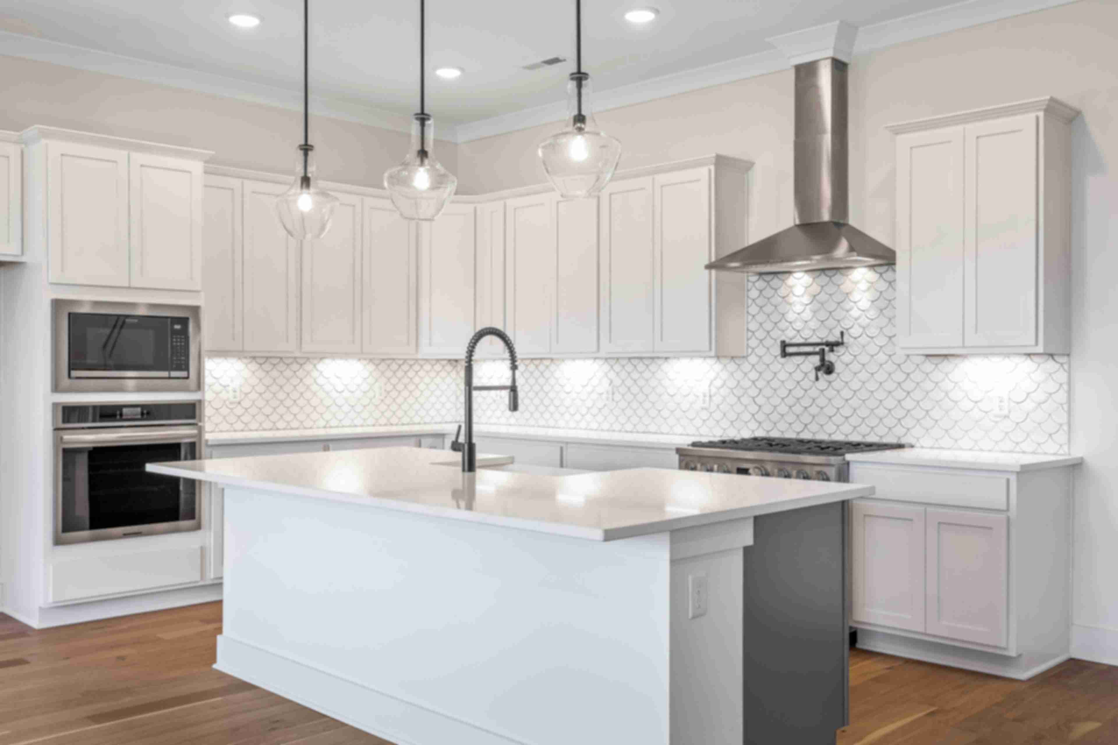 Spacious white kitchen with central island, subway tile backsplash, and pendant lights at Shelton Square in Murfreesboro TN