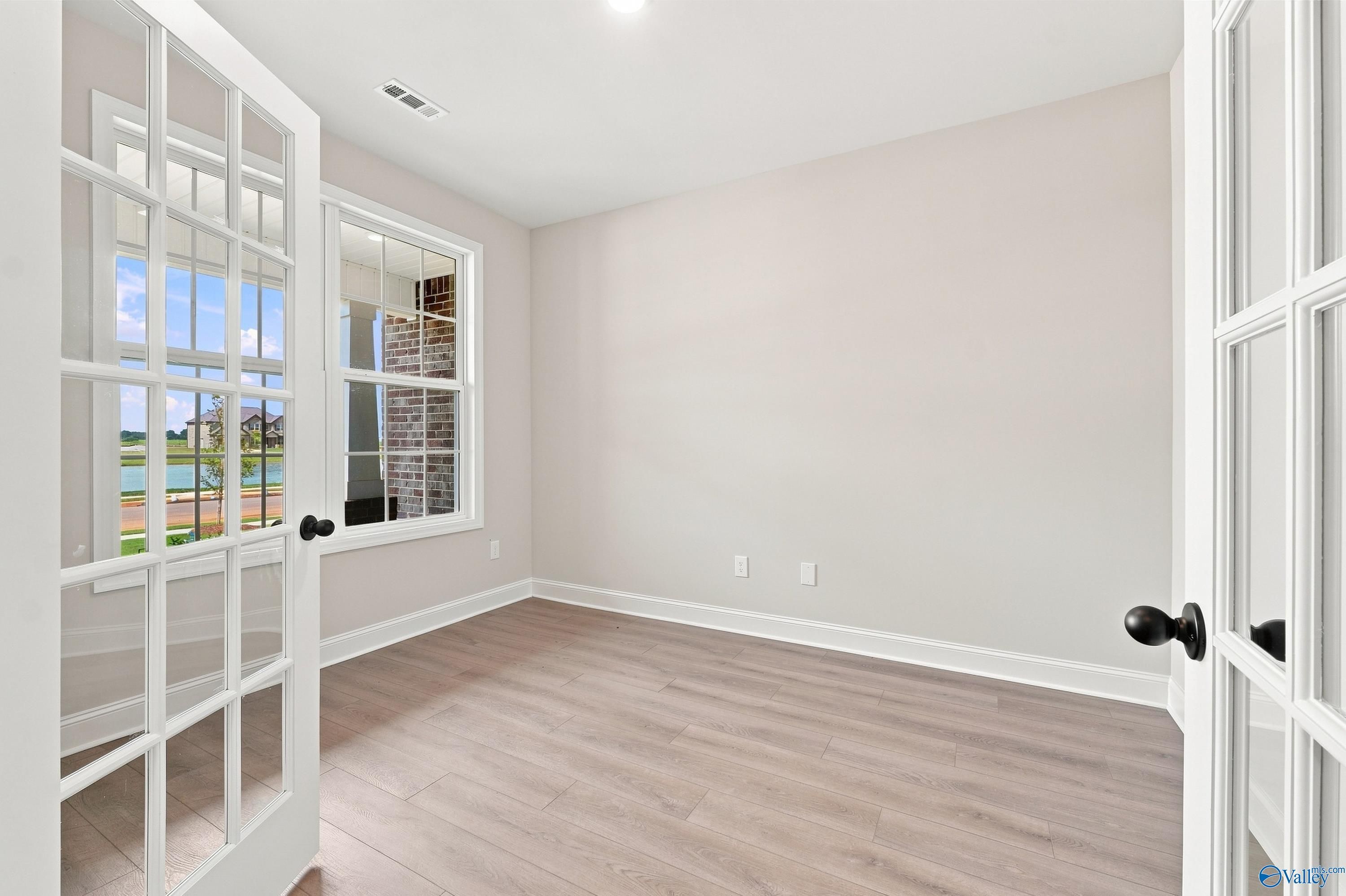 Bright home office with French doors and light wood floors in The Rockford B floor plan at Kendall Downs, Toney, Alabama.