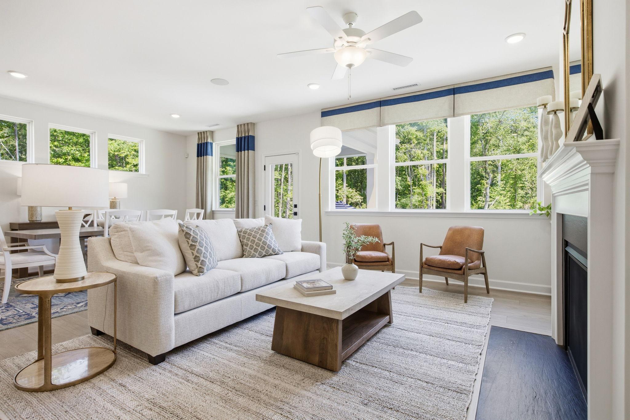 Bright, open-concept living room in The Ashport K by Davidson Homes, featuring a cozy fireplace and modern furniture.