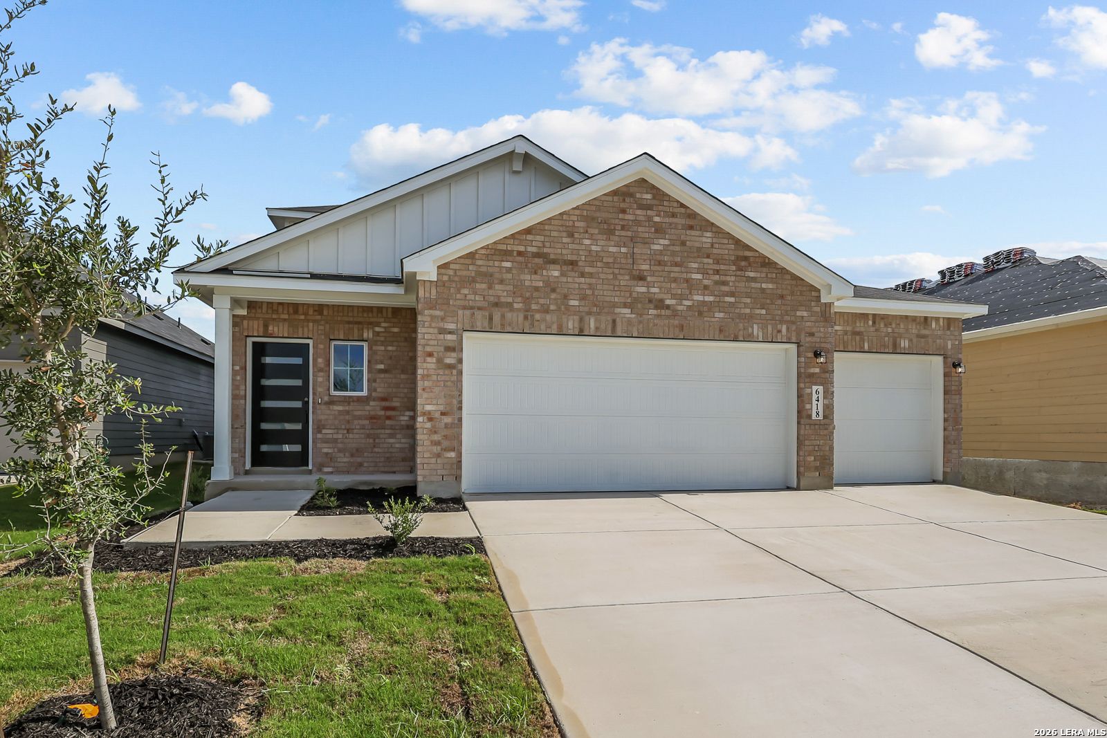Brick exterior with 3-car garage and covered porch at Davidson Homes' Pinecrest F plan in Morgan Meadows, San Antonio, Texas