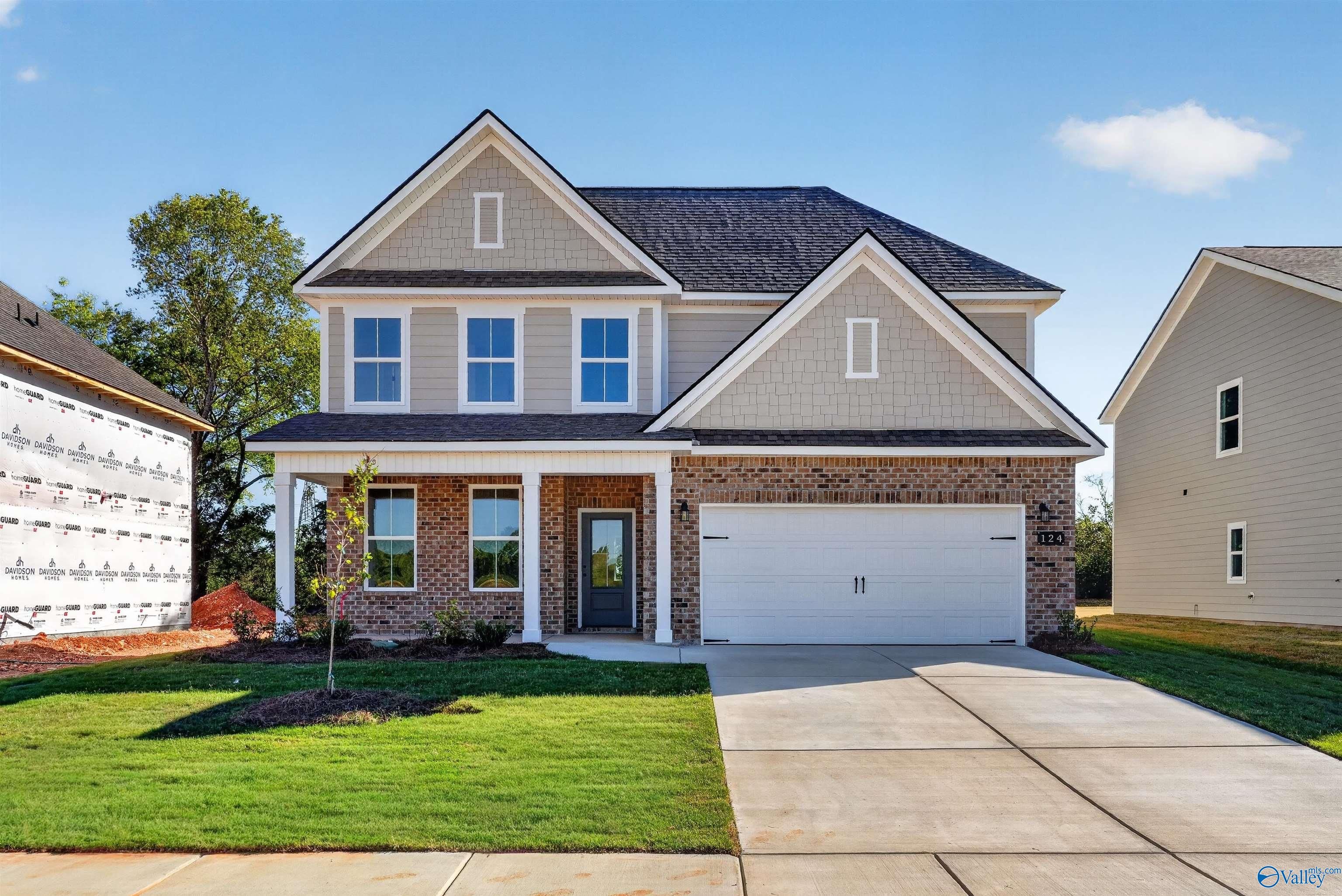 Two-story brick and shingle front elevation with covered porch and 2-car garage in Davidson Homes The Ashport L, Berry Cove, New Market, Alabama