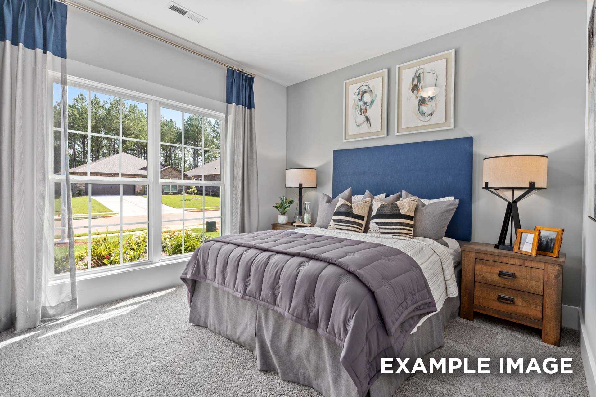 Spacious master bedroom in The Franklin C featuring large window with blue curtains, plush purple bedding, and neighborhood view