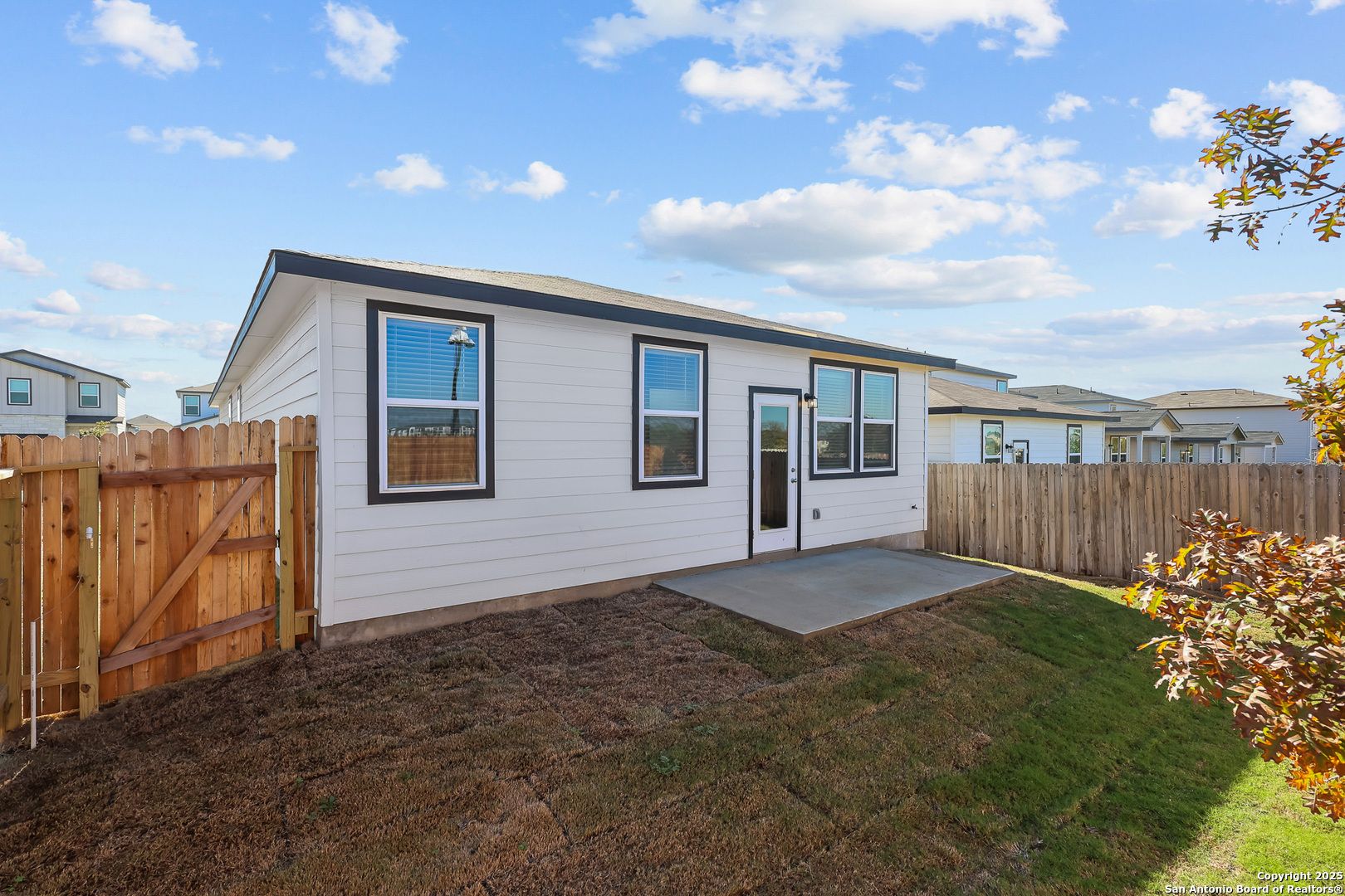 Backyard of single-story 4-bedroom Davidson Homes The Colorado B with concrete patio, wooden fence, and lush grass in Applewhite Meadows, San Antonio, Texas