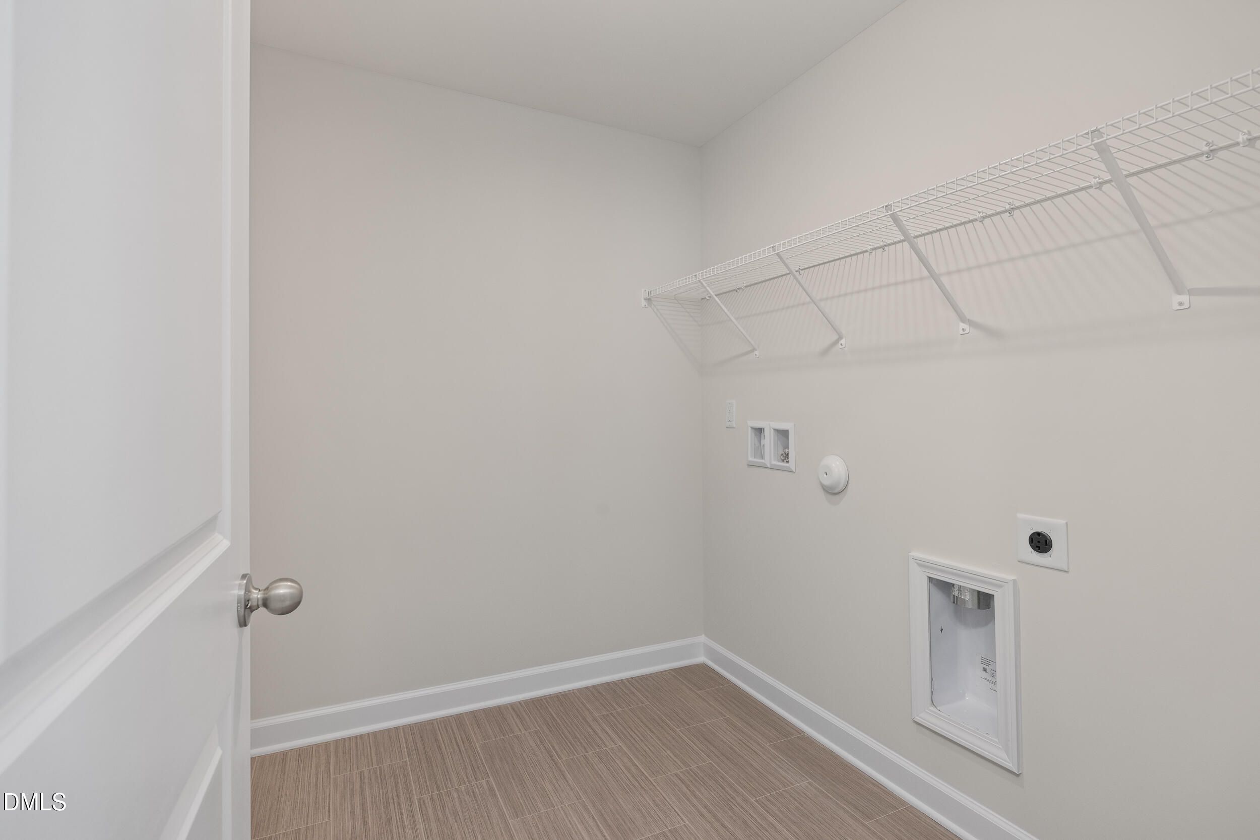 Bright laundry room with wire shelving, utility sink, and washer/dryer hookups in 4-bedroom Preston C home, Lillington, NC