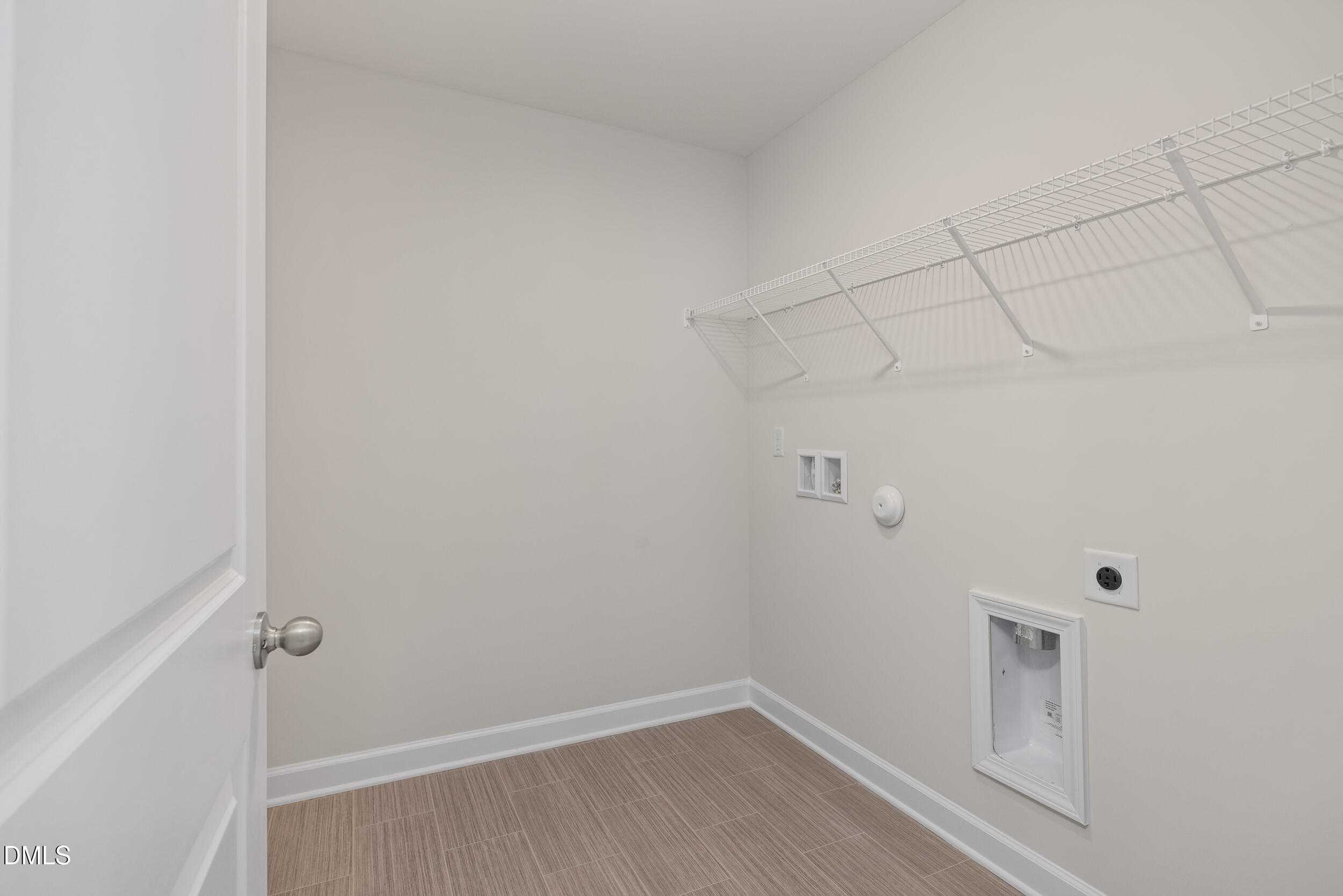 Bright laundry room with wire shelving, utility sink, and washer/dryer hookups in 4-bedroom Preston C home, Lillington, NC