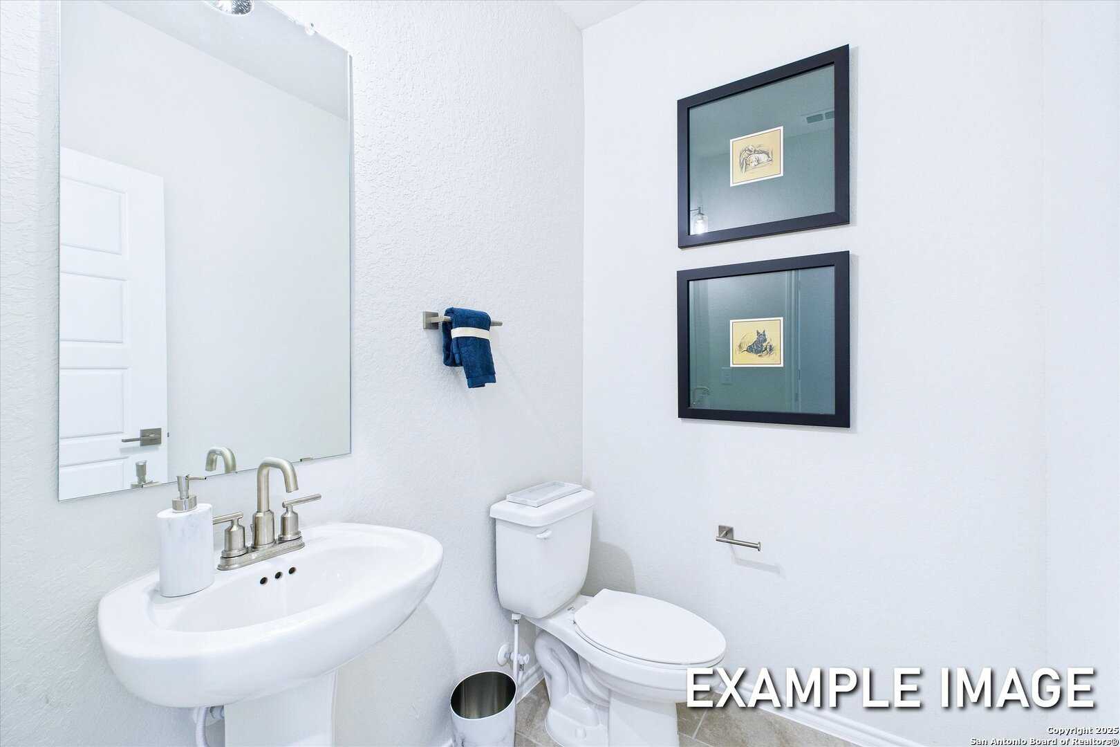 Modern powder room with white vanity, chrome faucet, toilet, and blue towel in Davidson Homes The Gillian C, San Antonio