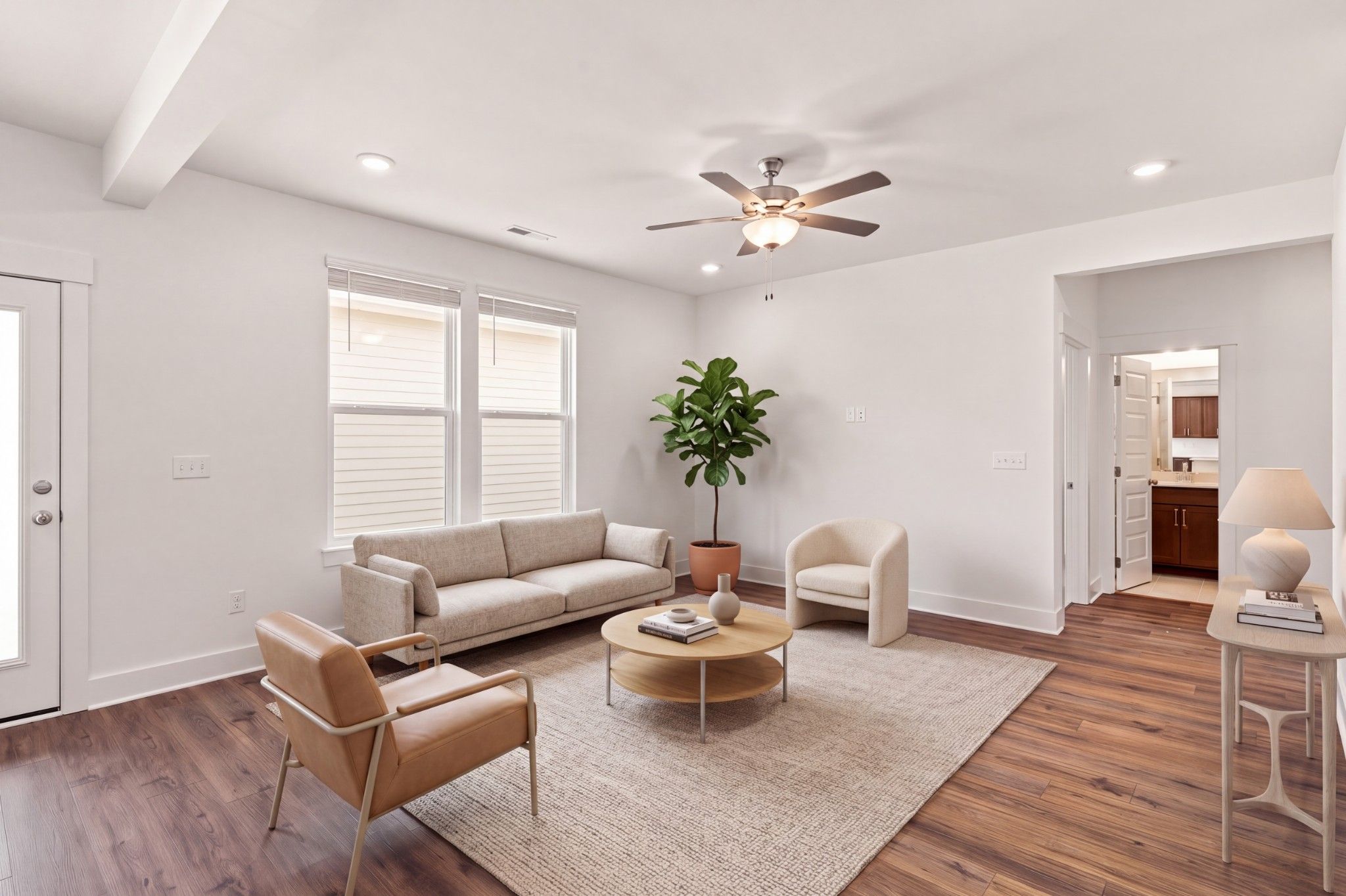 Bright living room with hardwood floors, ceiling fan, and neutral seating in Davidson Homes The Willow C, Gallatin, Tennessee