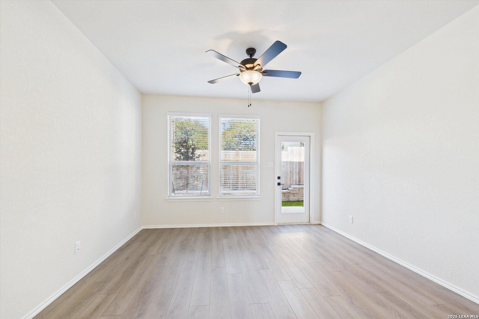 Bright empty bedroom with ceiling fan, large windows, and glass patio door in Davidson Homes The Gillian B, San Antonio