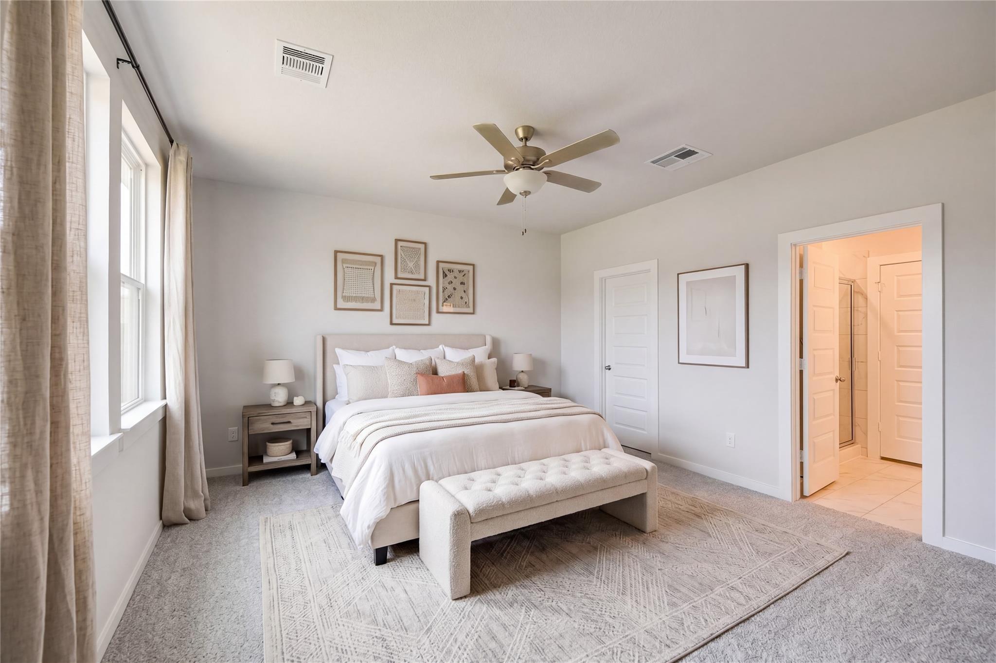 Bright primary bedroom with ceiling fan, neutral bedding, and en suite bath in Davidson Homes Sabine F, Cleveland, Texas