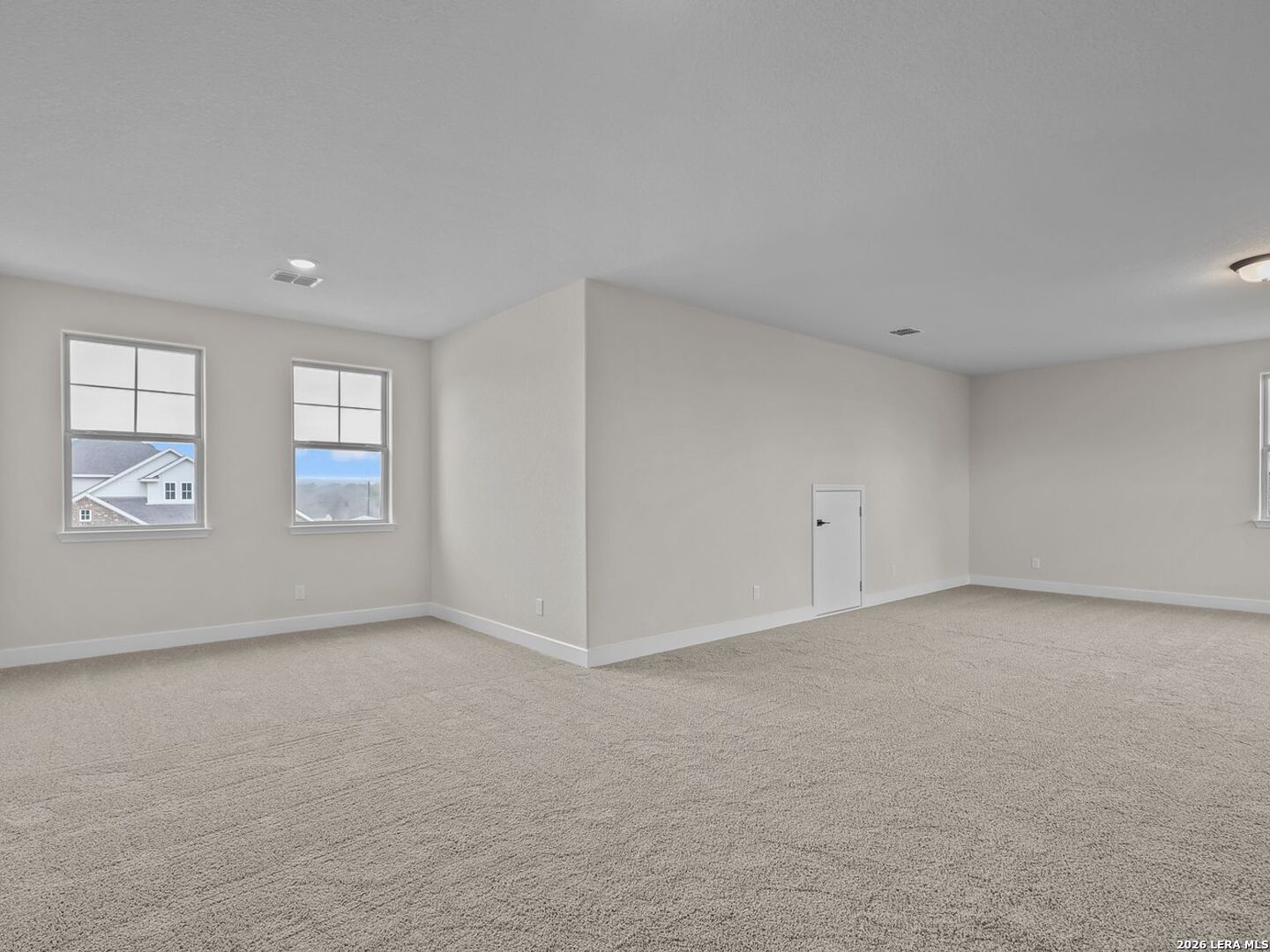 Spacious carpeted game room or second-story living area in The Belmont H floor plan at Potranco Oaks, Castroville, Texas.