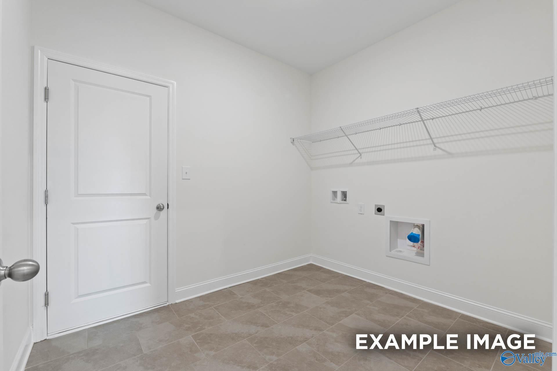 Bright laundry room with utility sink, wire shelving, and washer-dryer hookups in Davidson Homes The Oxford, Riverton Preserve, Huntsville, Alabama