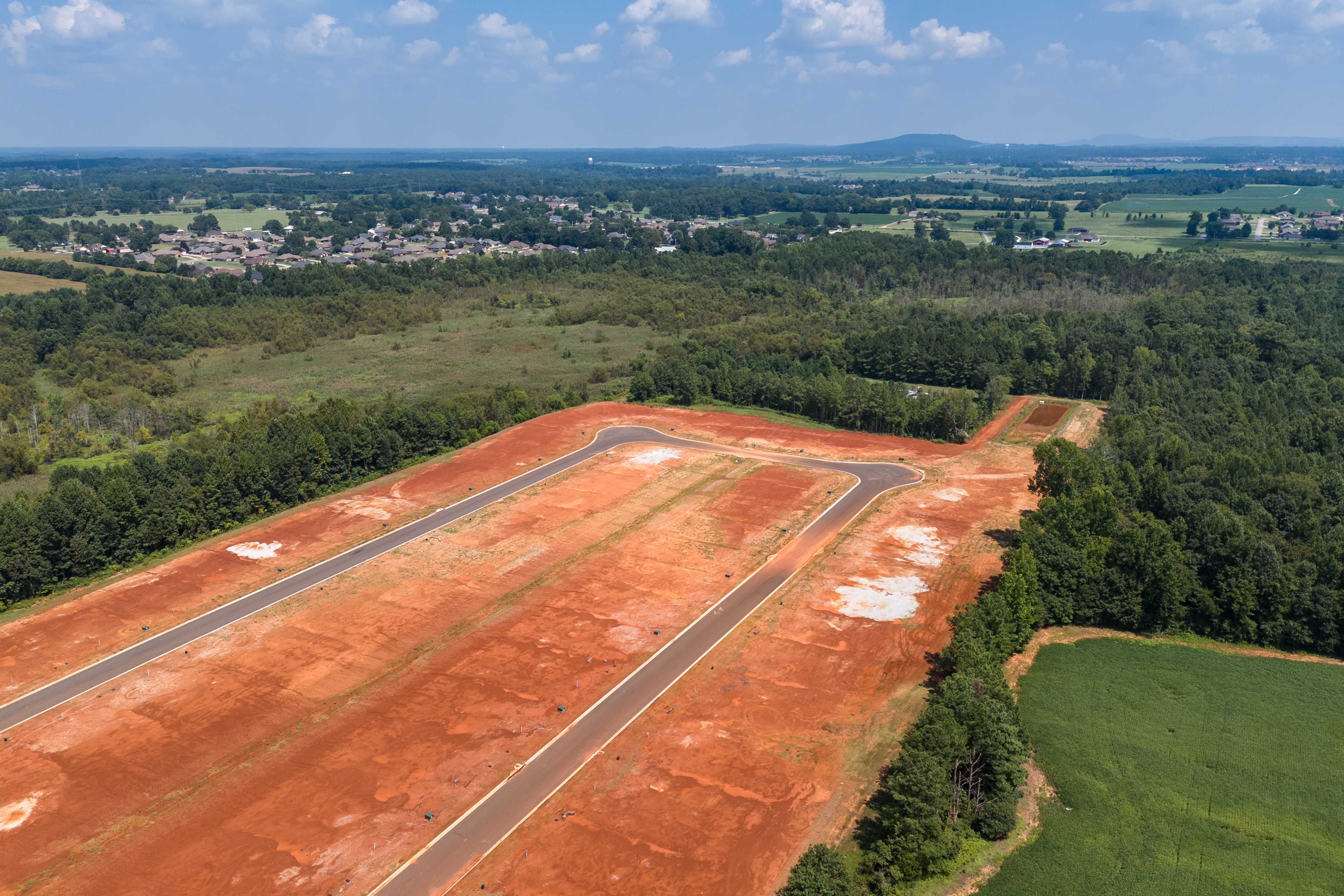 Aerial view of Ricketts Farm neighborhood development in Athens Alabama with new red dirt streets surrounded by forests and fields