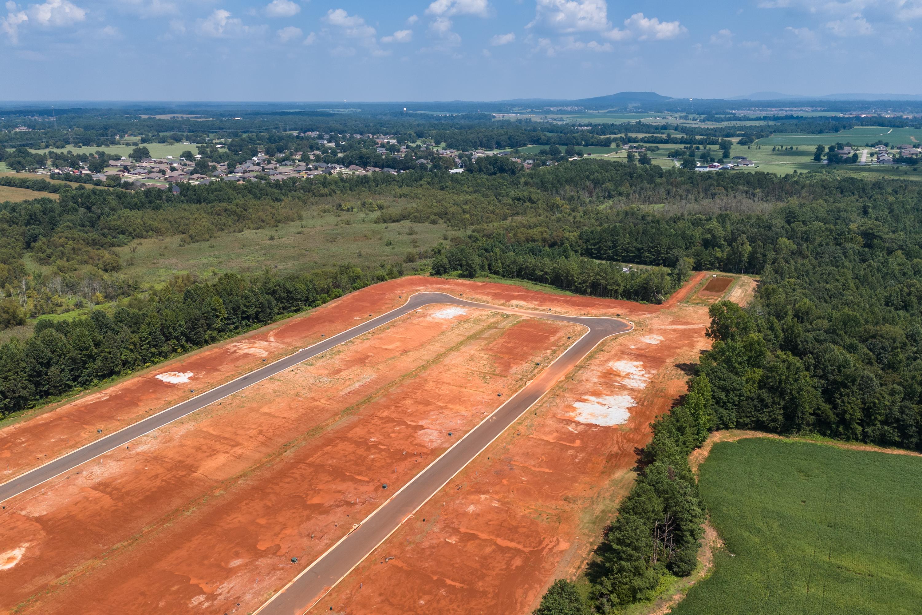 Aerial view of Ricketts Farm neighborhood development in Athens Alabama with new red dirt streets surrounded by forests and fields