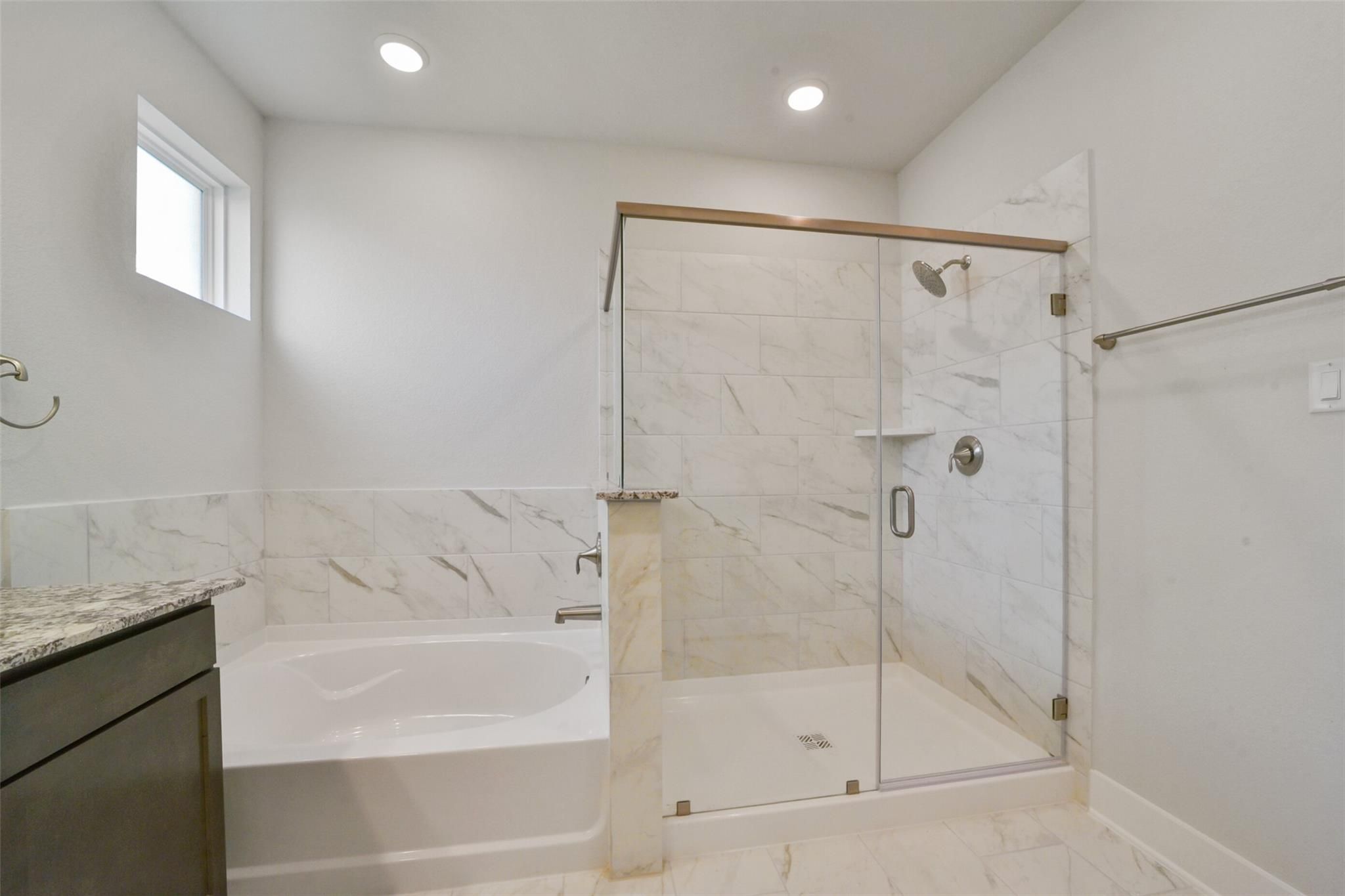 Modern master bathroom with frameless glass shower, freestanding tub, marble vanity in Davidson Homes The Zion A, Texas City