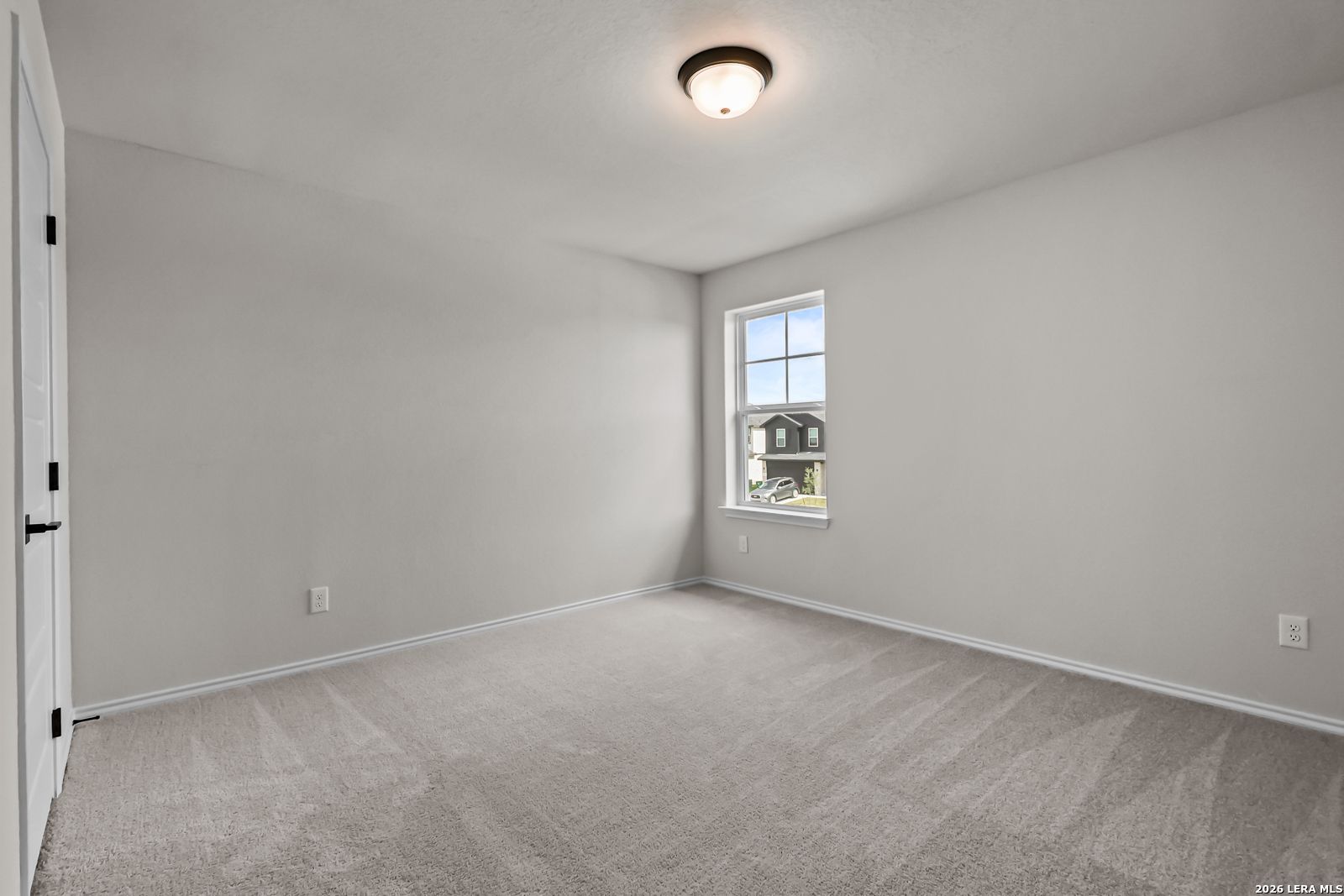 Spacious secondary bedroom with neutral carpet in The Douglas C floor plan by Davidson Homes in Hannah Heights, Seguin, Texas.
