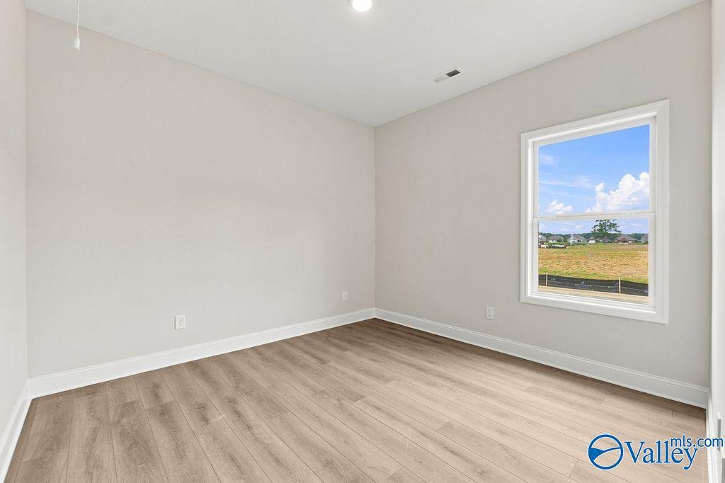 Bright bedroom with wood-look flooring in The Camilla B floor plan at The Retreat at Cain Park in Hartselle, Alabama.