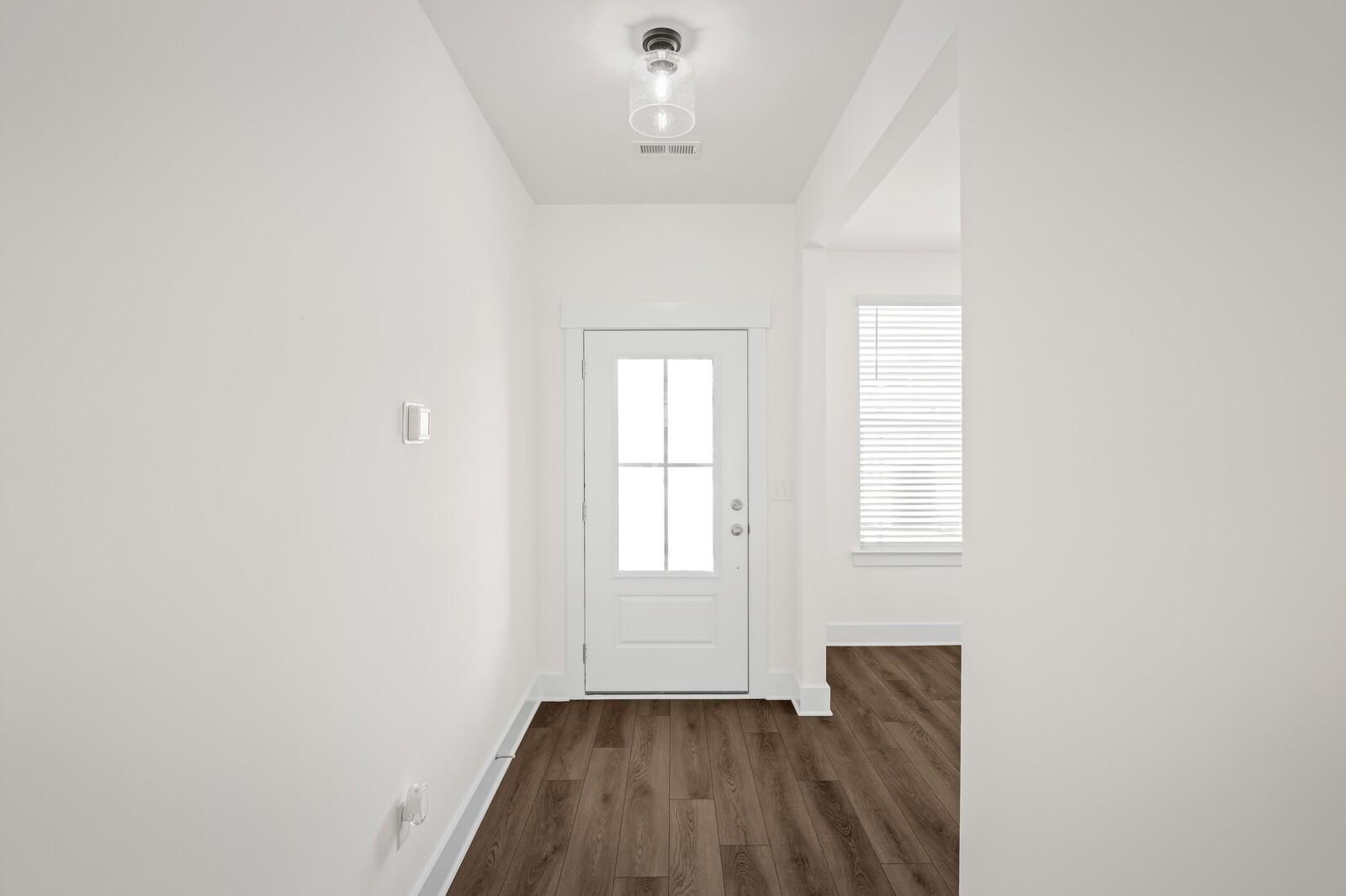 Bright entryway with modern light fixture and wood-look flooring at The Willow floor plan in Woods Crossing, Gallatin, TN.