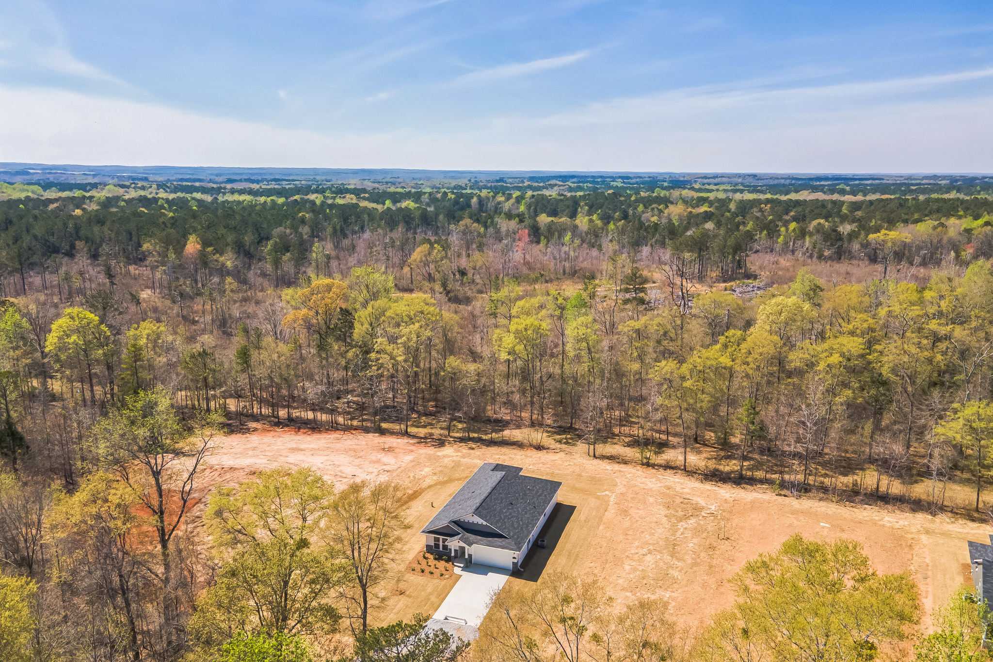 Aerial view of modern single-story home at Silver Oak in Cusseta Alabama with wooded surroundings