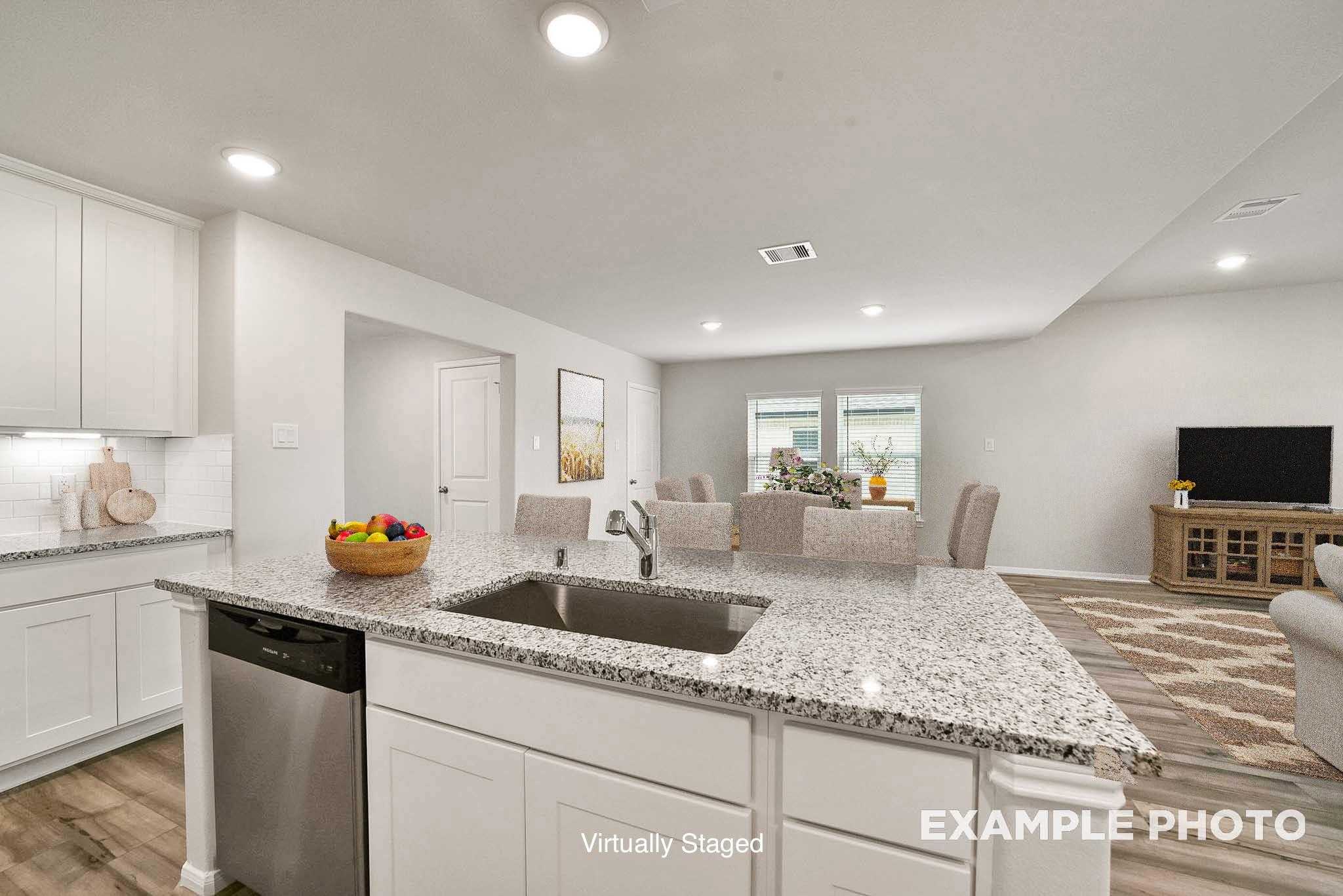 Bright open-concept kitchen with white cabinets, granite island sink, stainless dishwasher, adjacent dining area in Davidson Homes Tierra B, Beasley TX